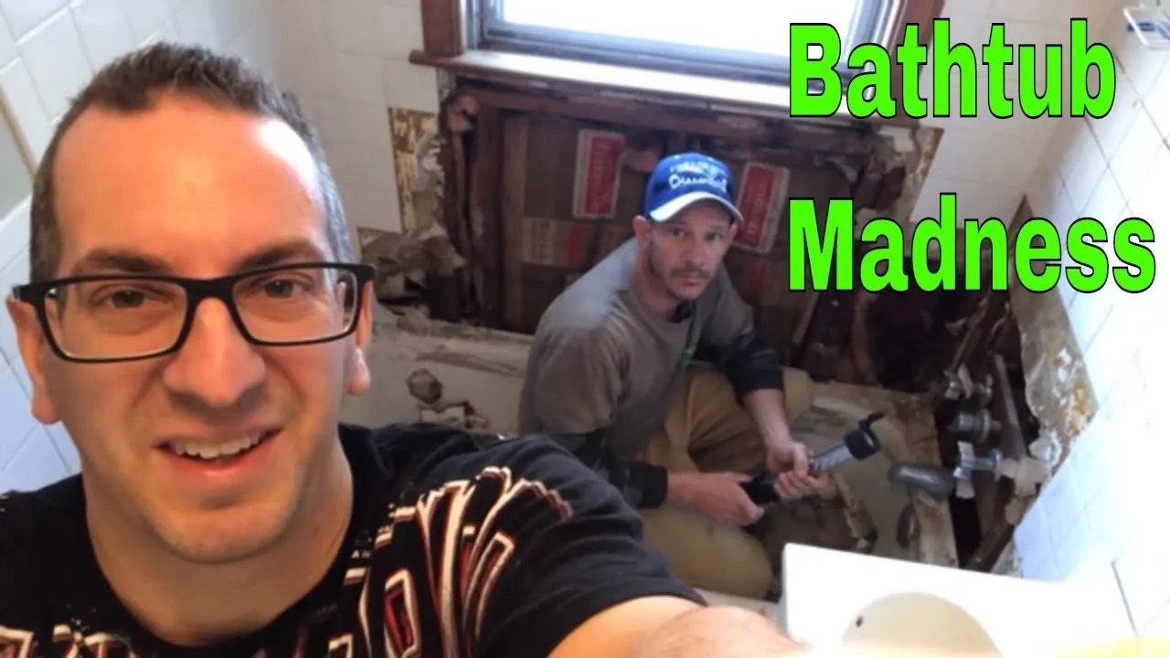 Two men working on a bathtub renovation project in a bathroom.