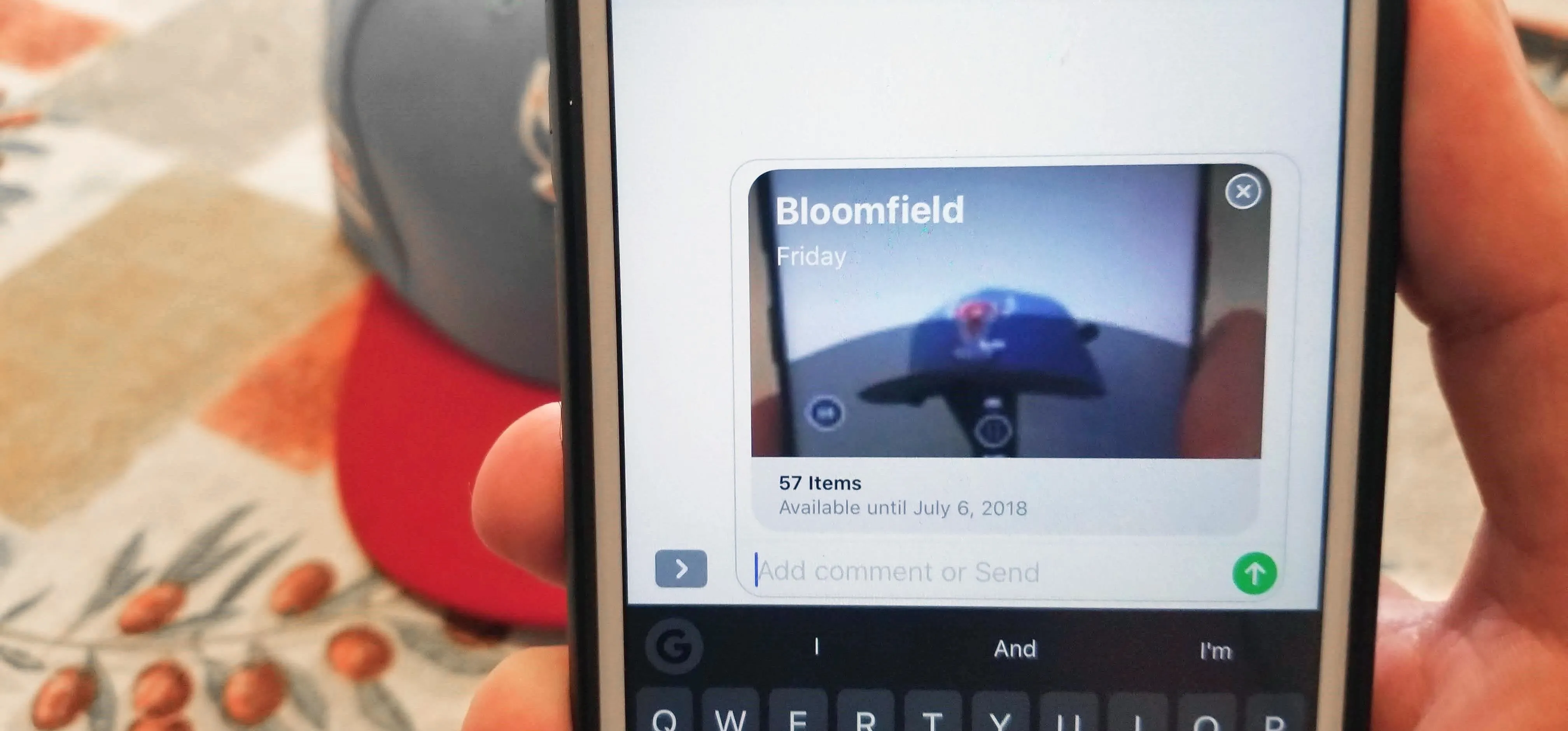 Person holding a smartphone displaying a location marked as "Bloomfield."