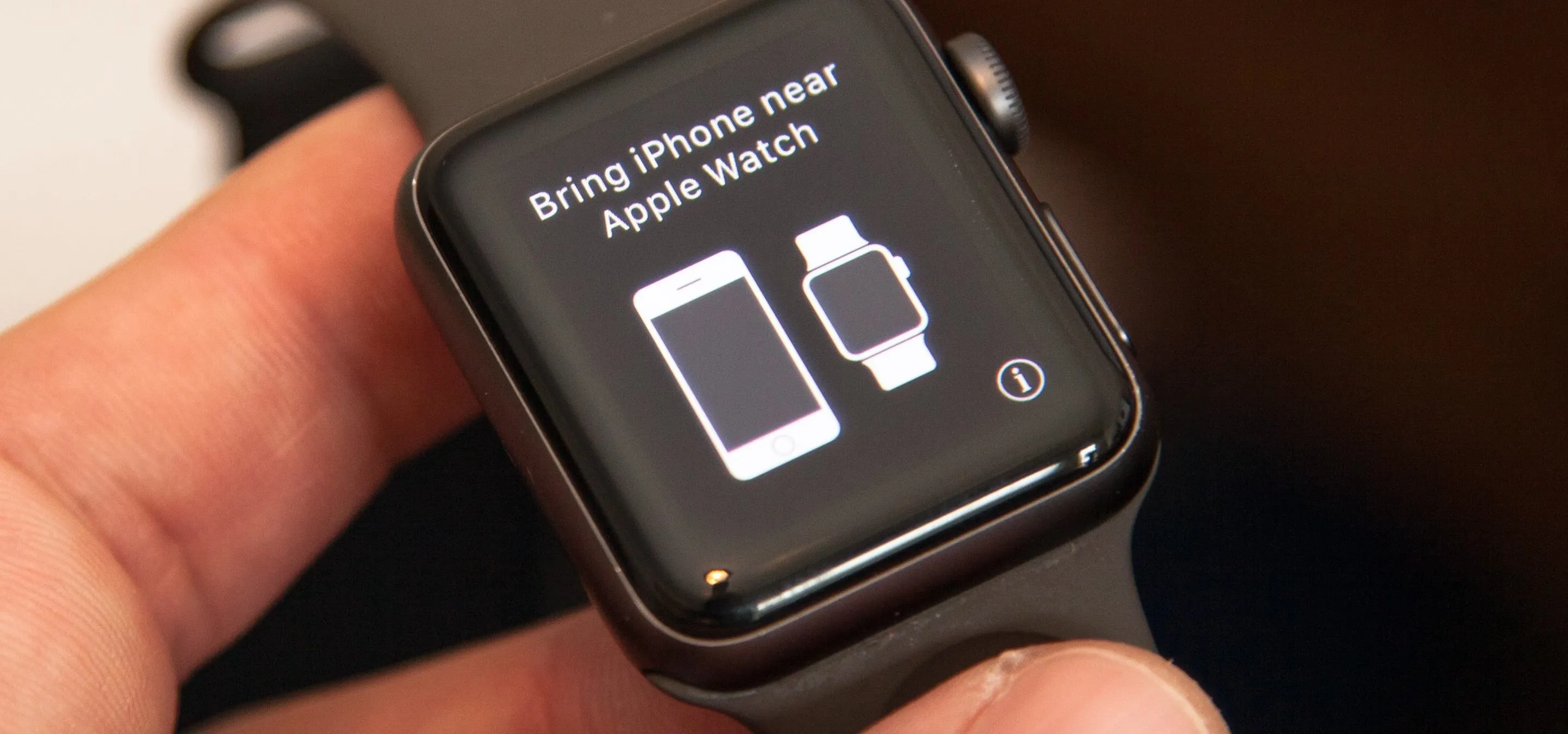 Smartwatch display indicating to bring iPhone near for connectivity.