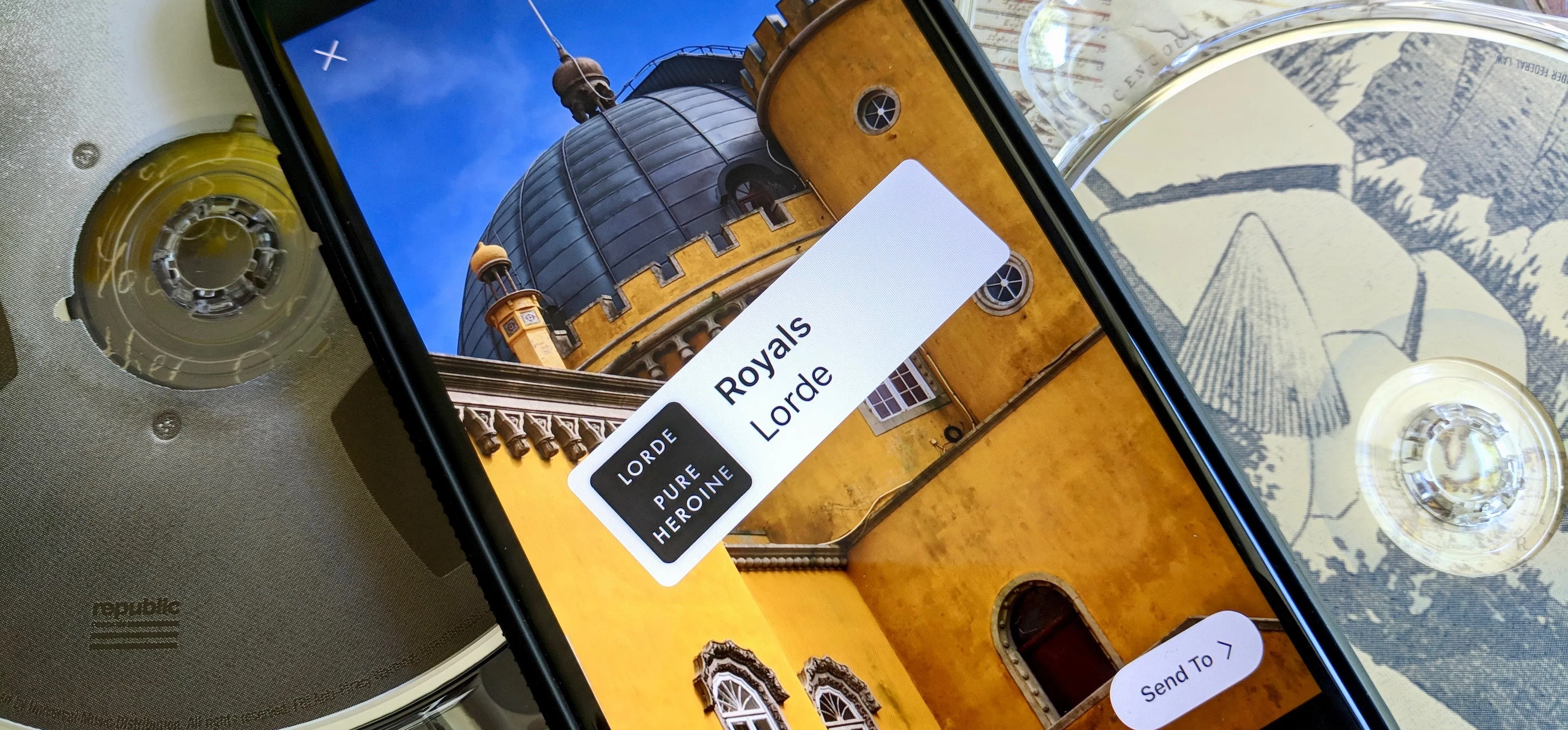 A smartphone displaying a photo of a yellow building with a dome, labeled "Regalia Landa."