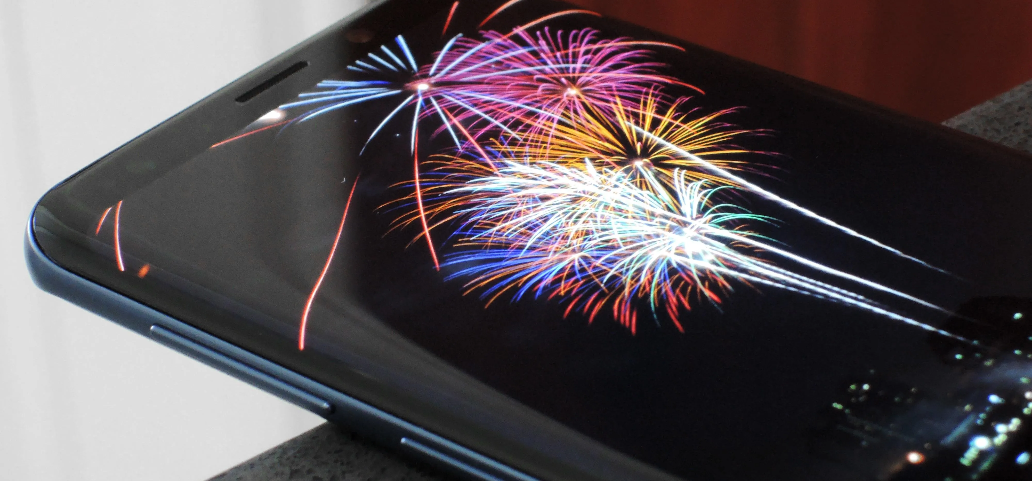 Smartphone displaying colorful fireworks on the screen.
