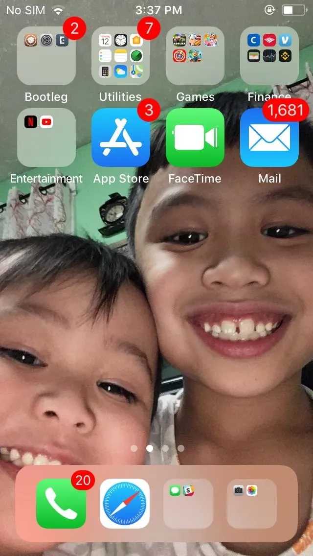 Two smiling children posing for a selfie with a smartphone screen displayed in the background.