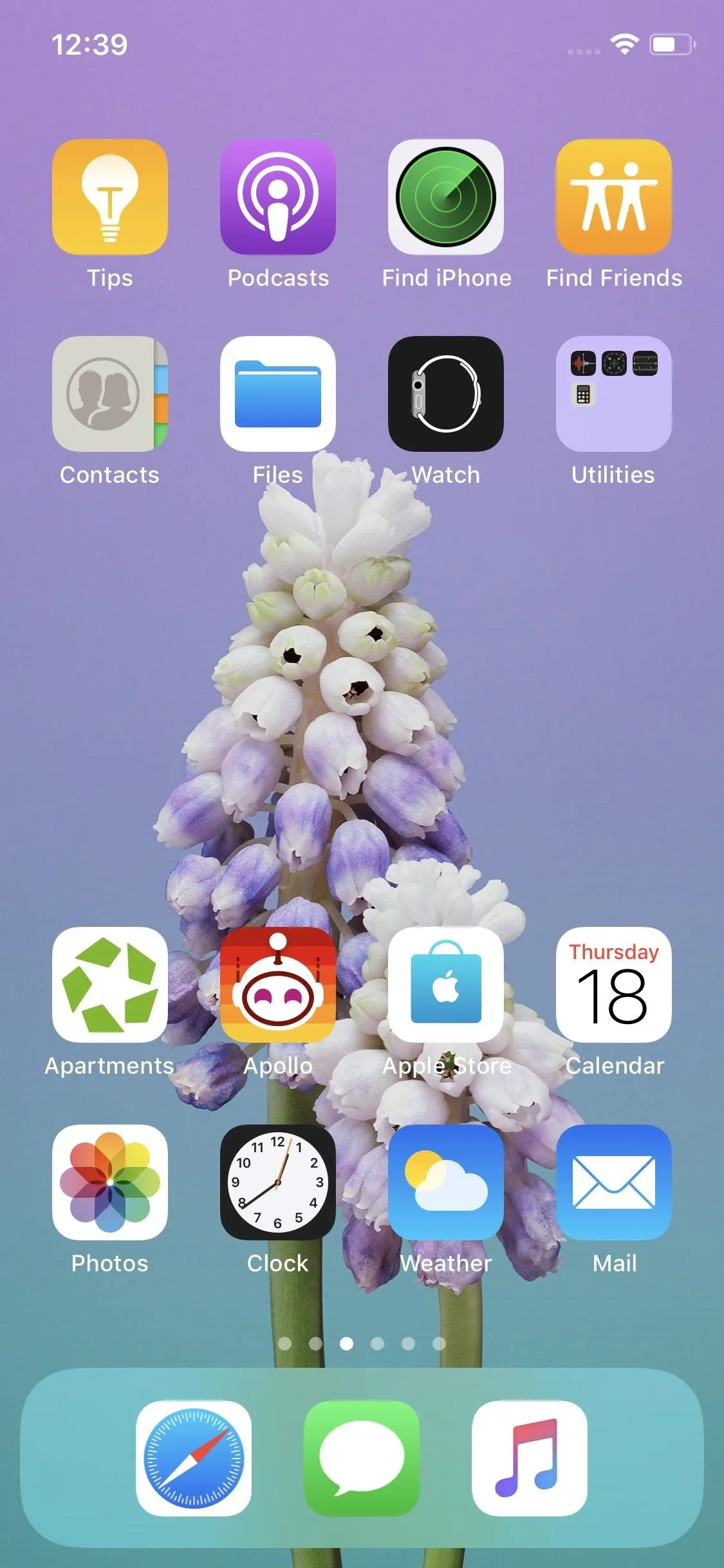 Mobile phone screen displaying a flower wallpaper with various app icons.