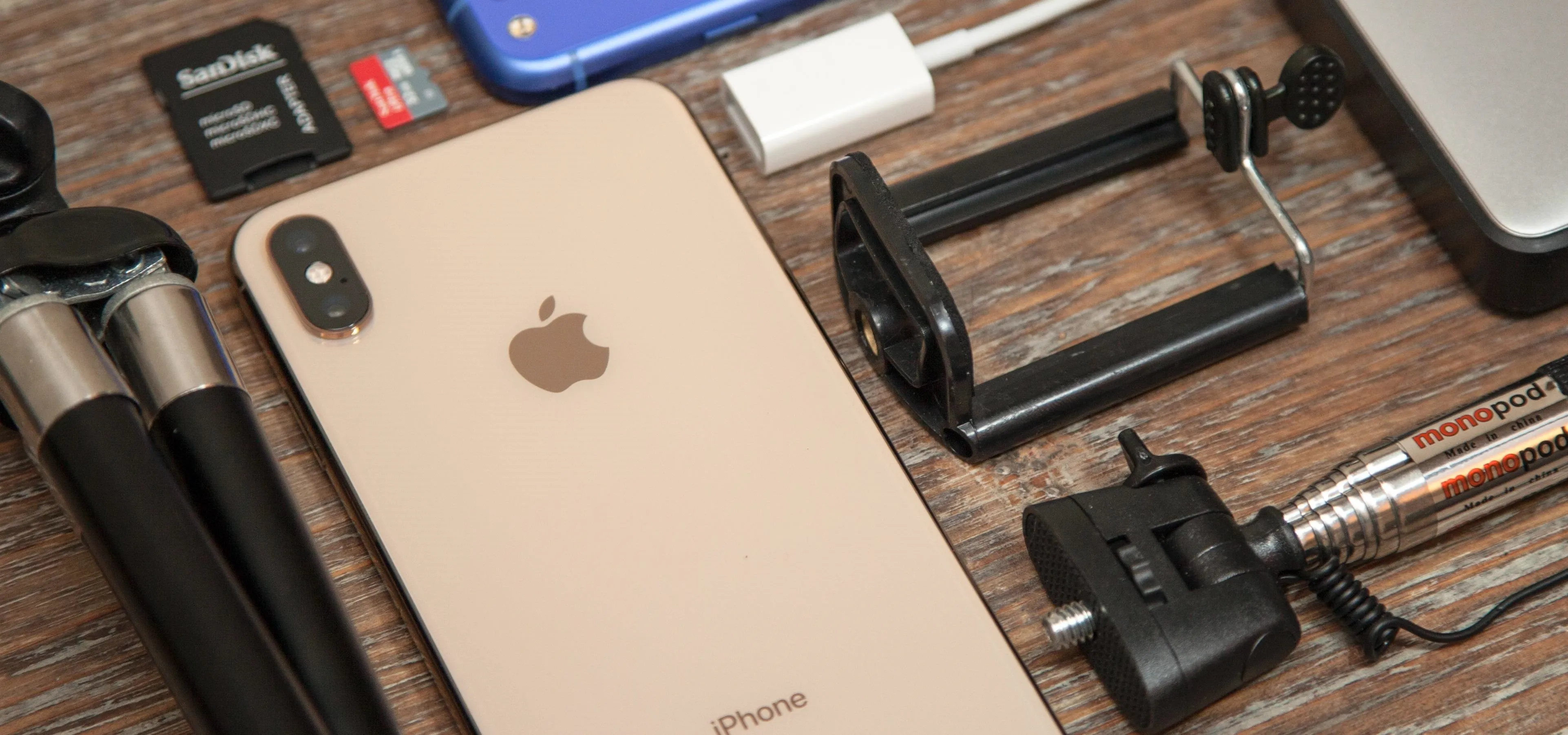Smartphone and photography accessories on a wooden surface.