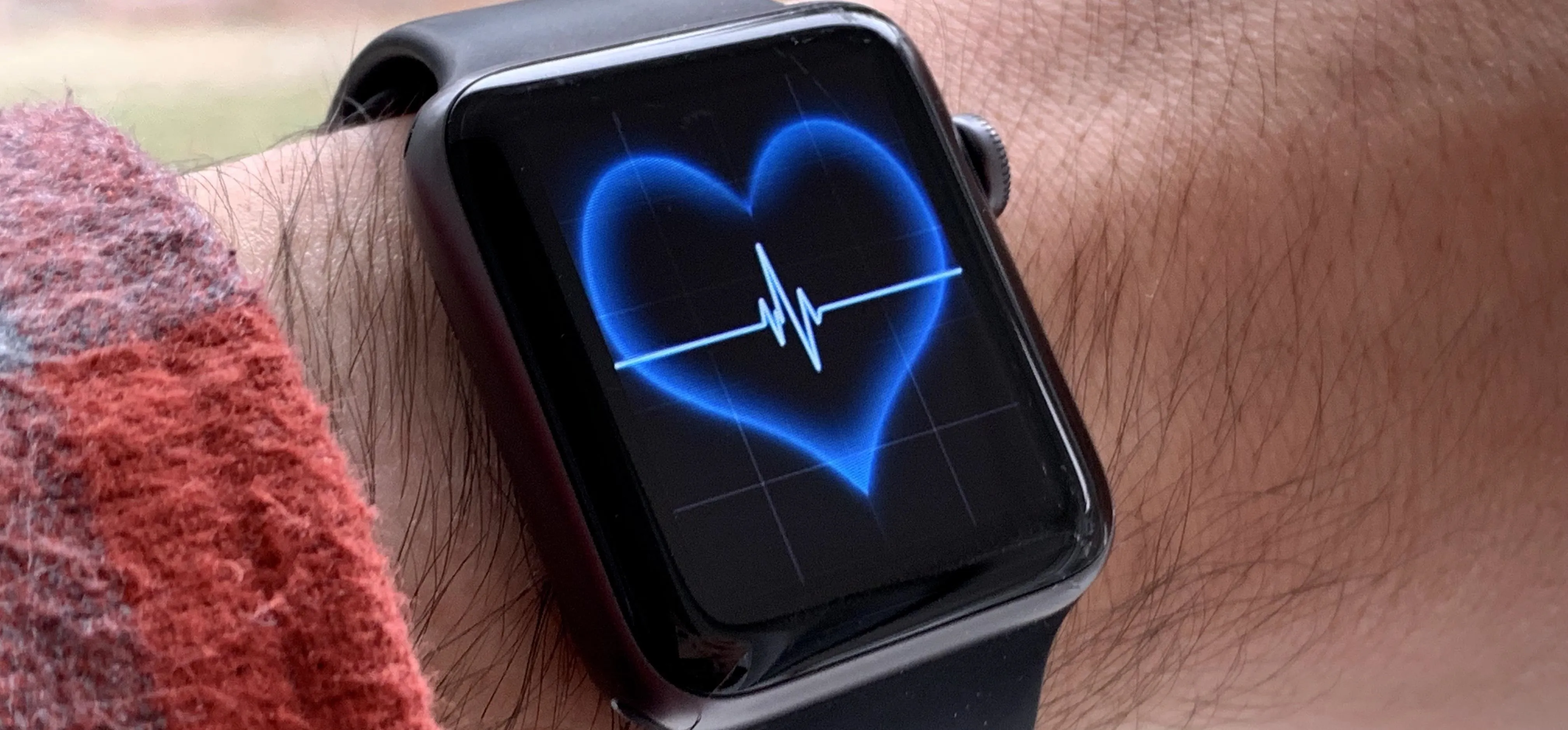 Smartwatch in a sleek white box on a wooden surface.