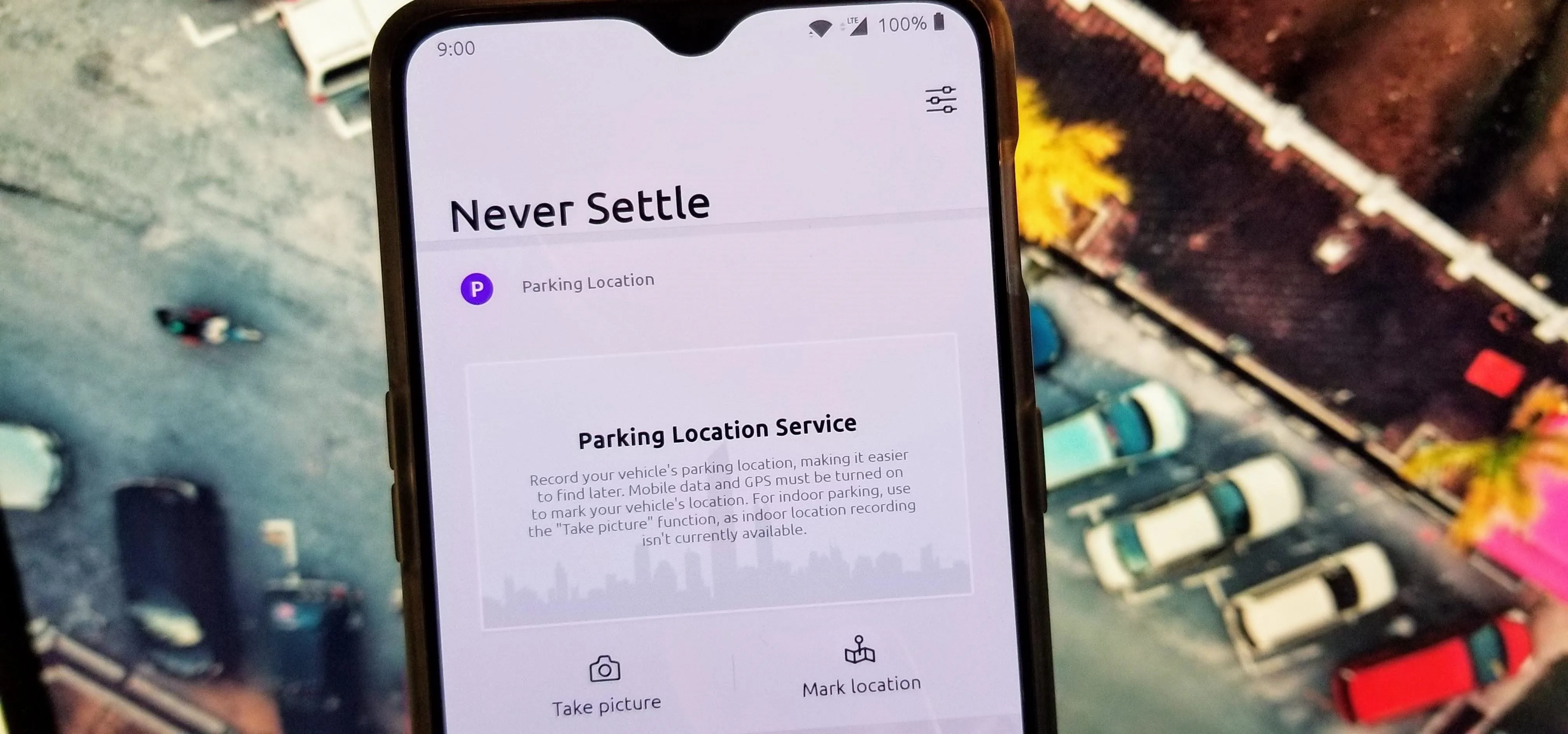 Smartphone displaying a 'Never Settle' message on its screen.