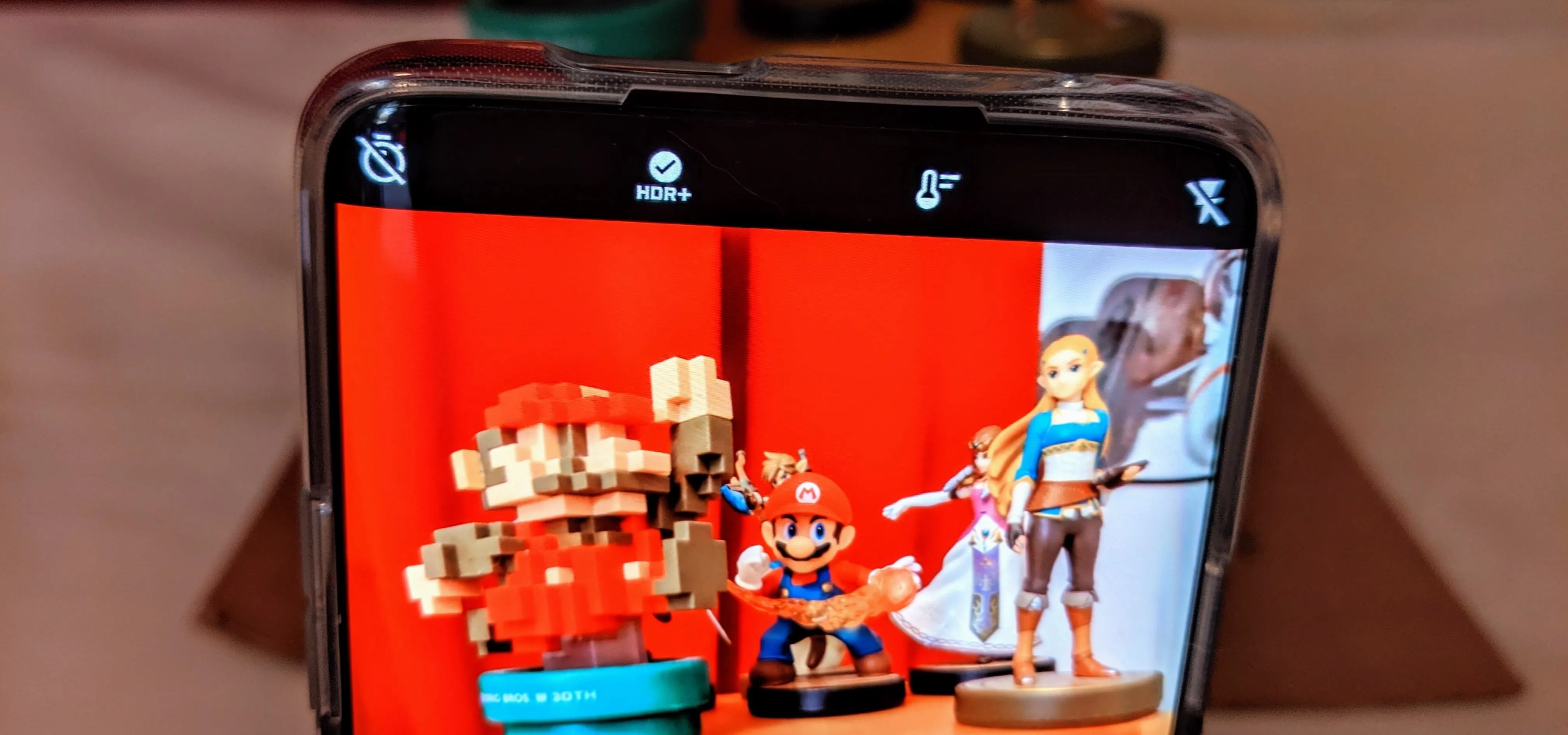 A smartphone displaying figurines of Mario and a female character.