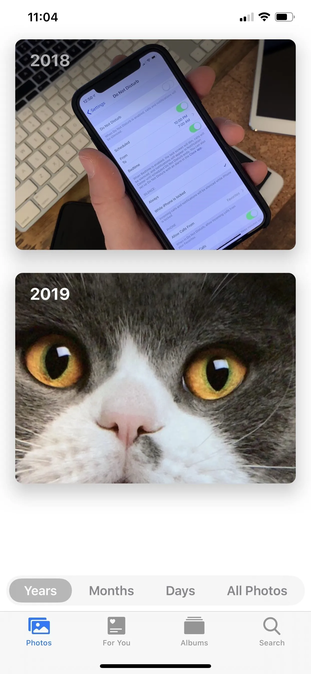 A mobile phone displaying text and a close-up of a cat's face.