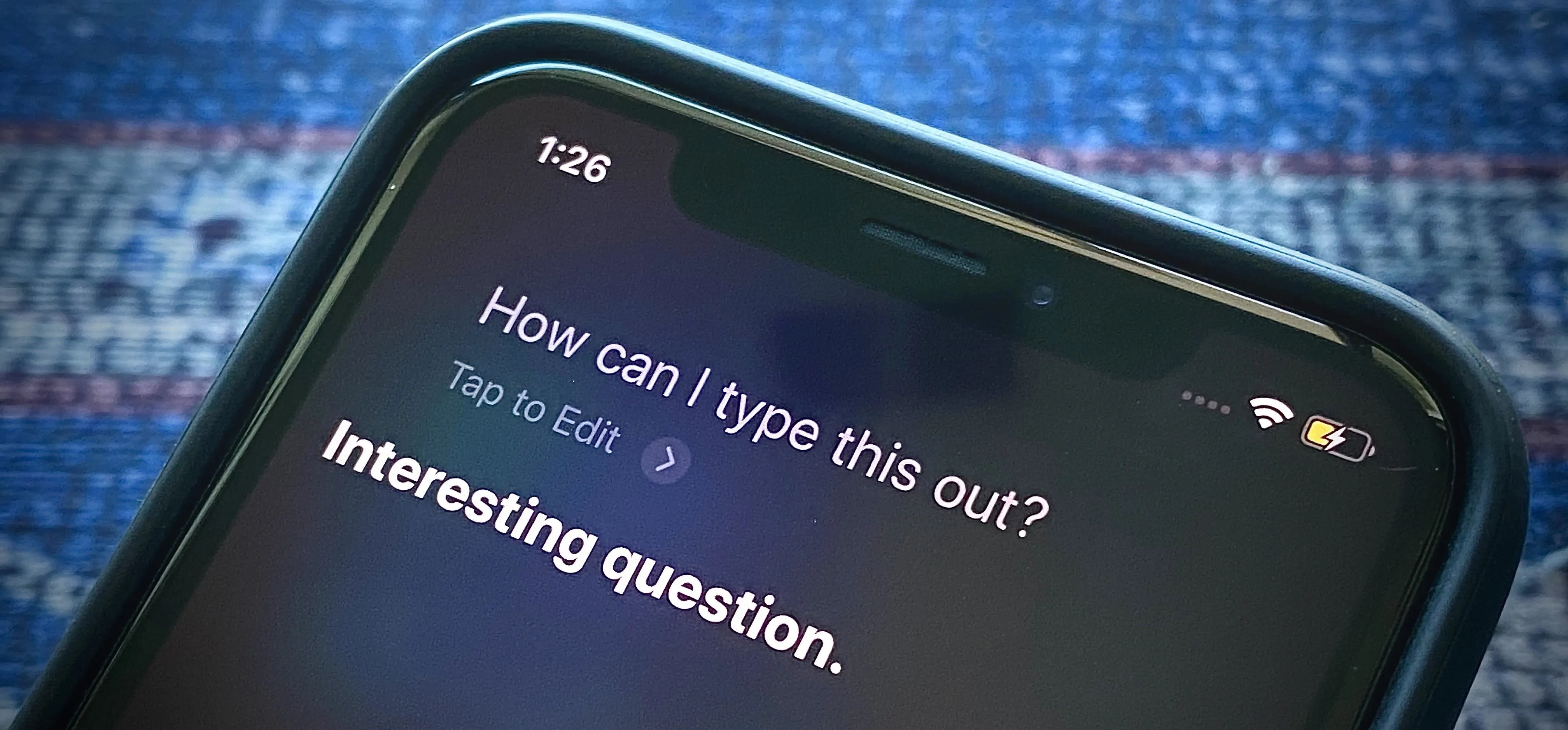 Smartphone screen displaying a voice assistant prompt with the text "How can I type this out? Interesting question."