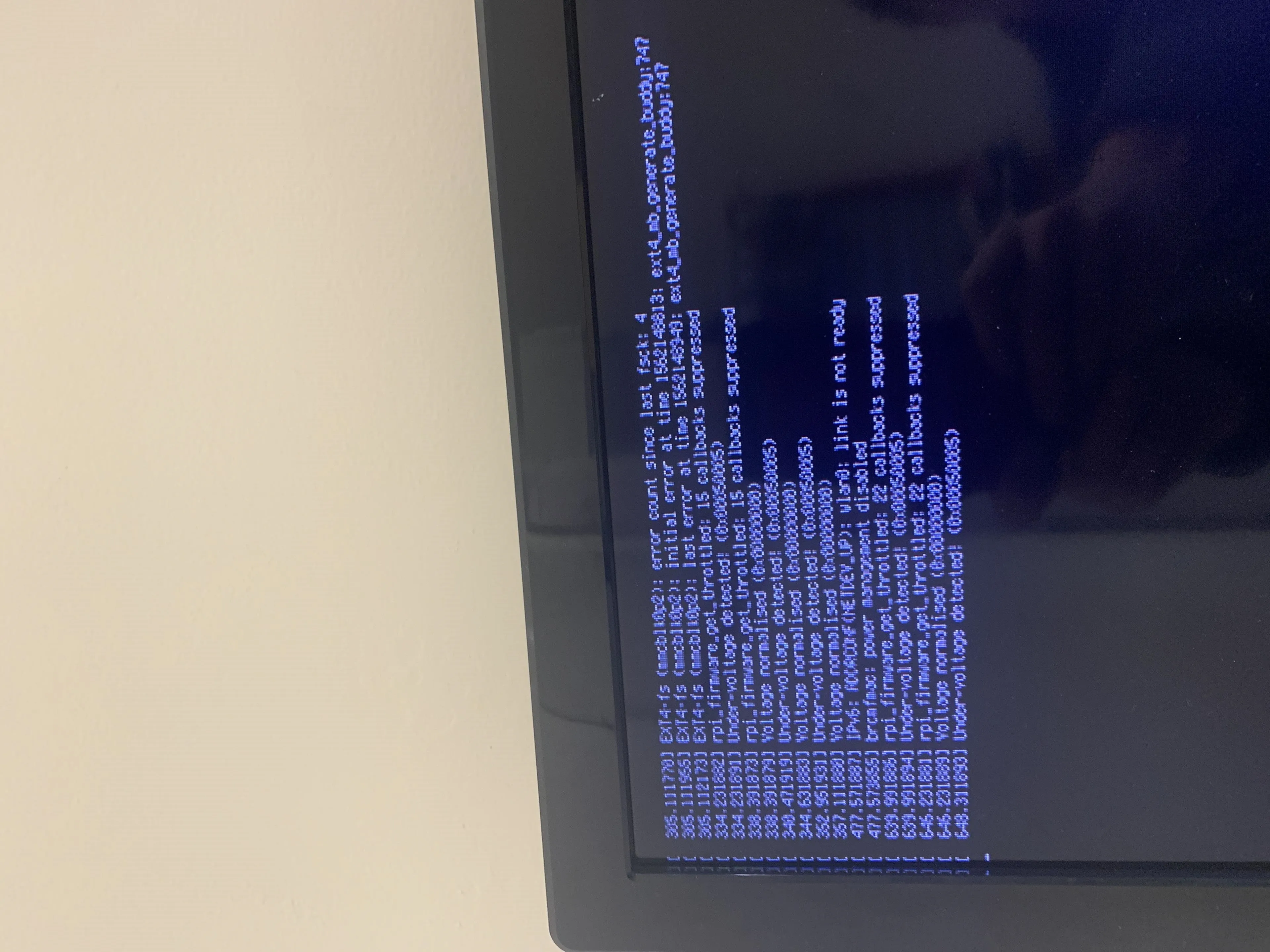 Computer screen displaying blue text on a black background, likely showing code or technical information.