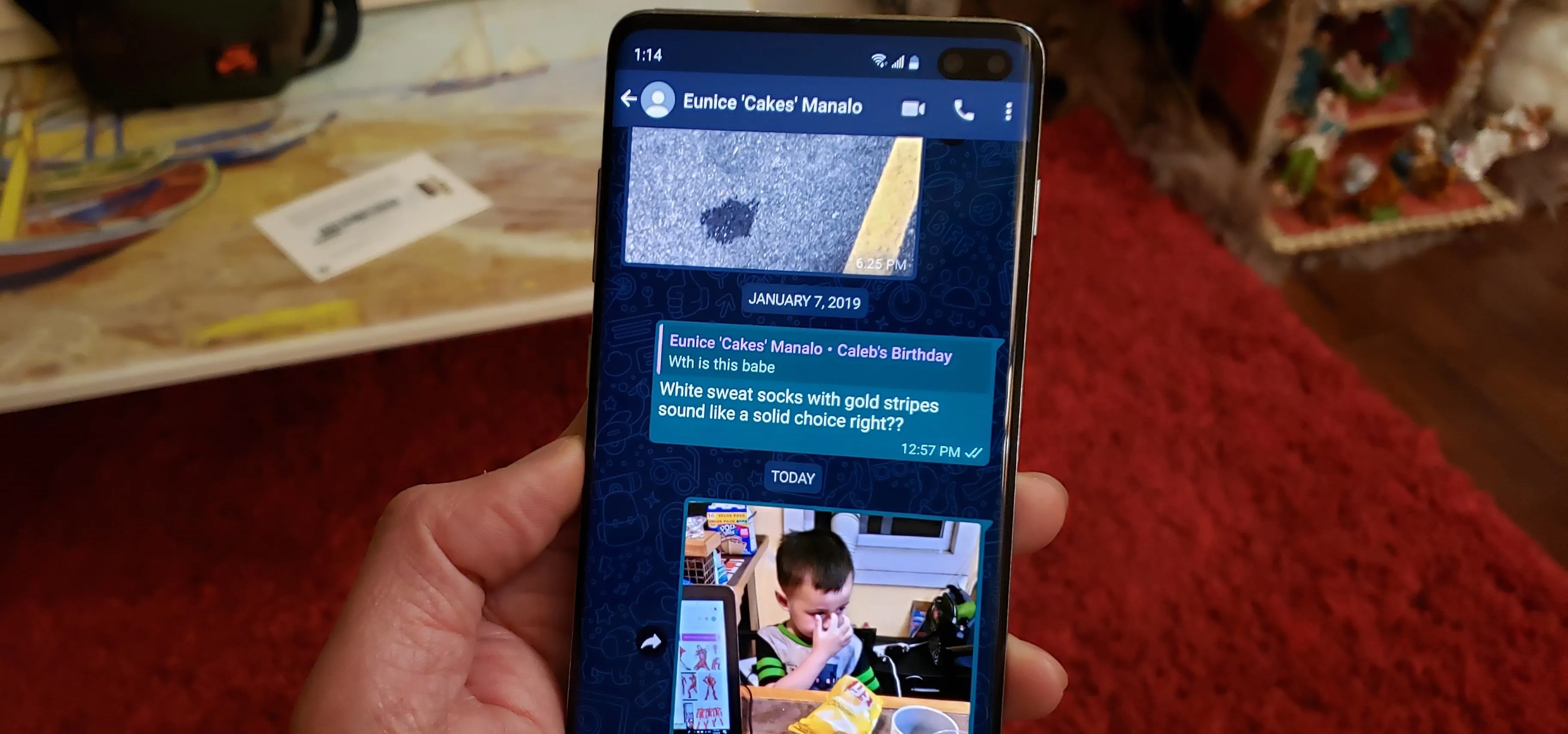 A smartphone displaying a WhatsApp conversation with images and text messages.