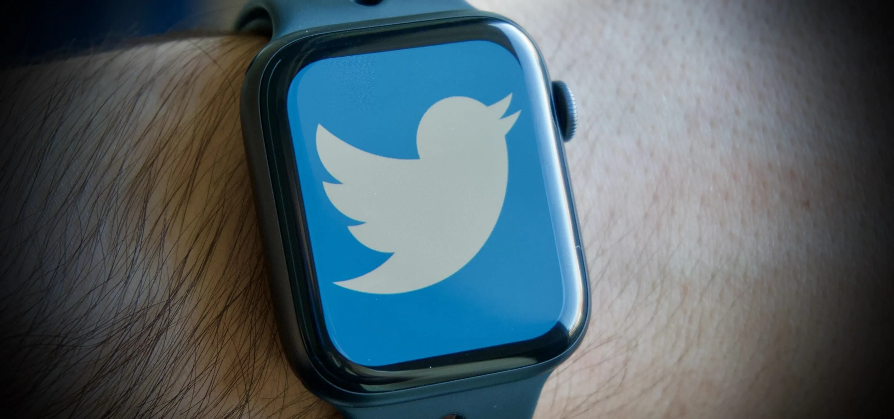 Smartwatch in a sleek white box on a wooden surface.