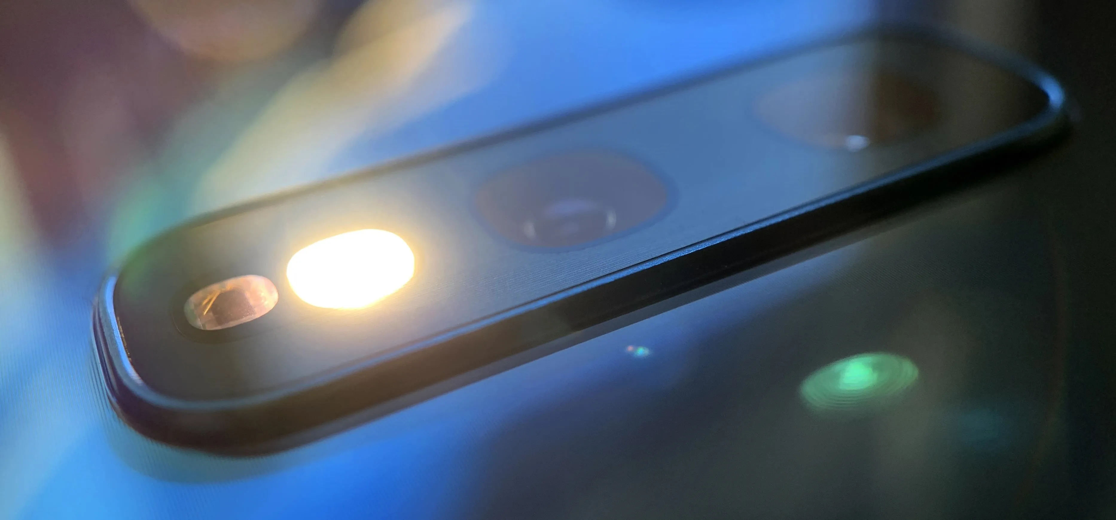 Close-up of a smartphone camera lens with a reflective surface.