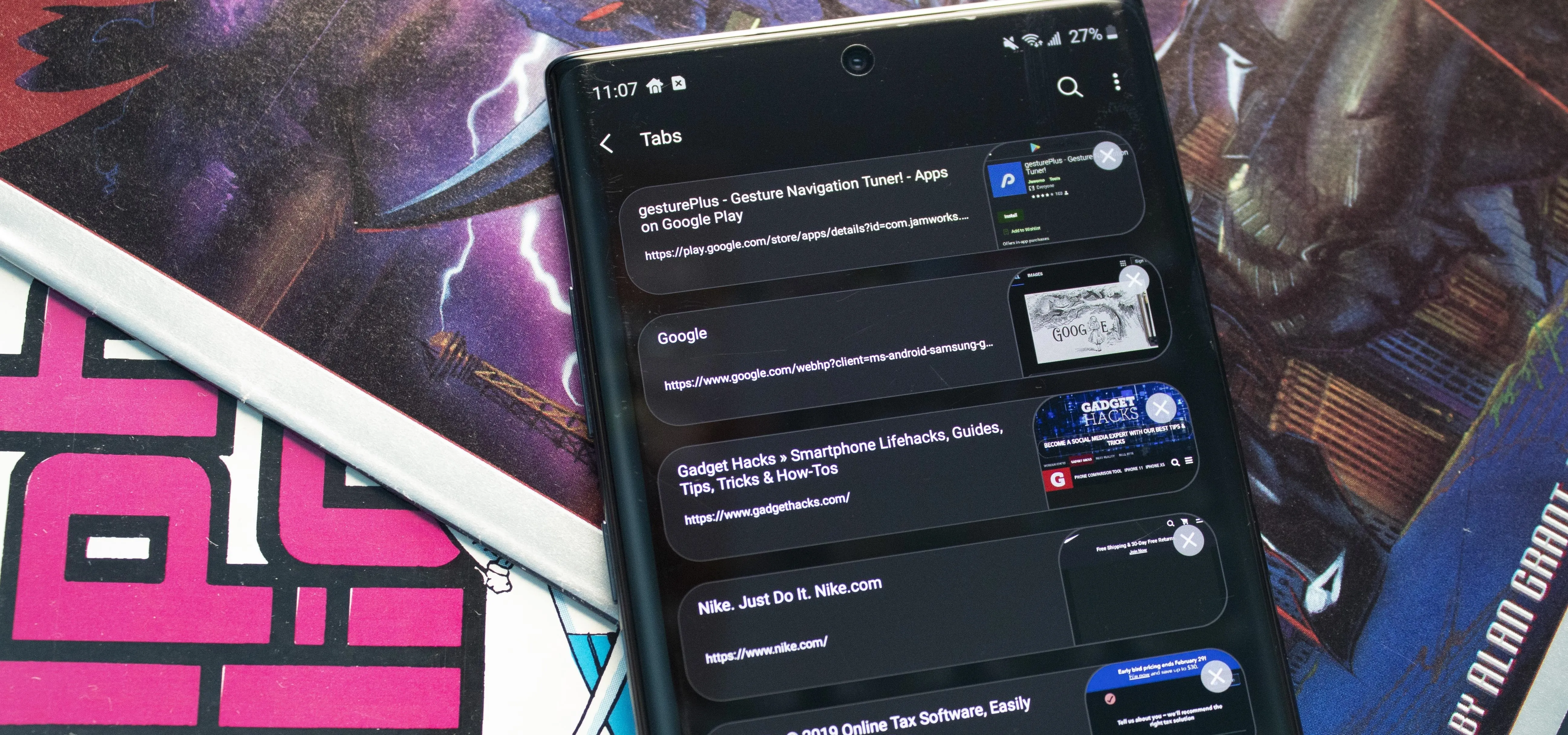 A smartphone displaying a dark-themed app interface, placed on top of colorful comic book covers.