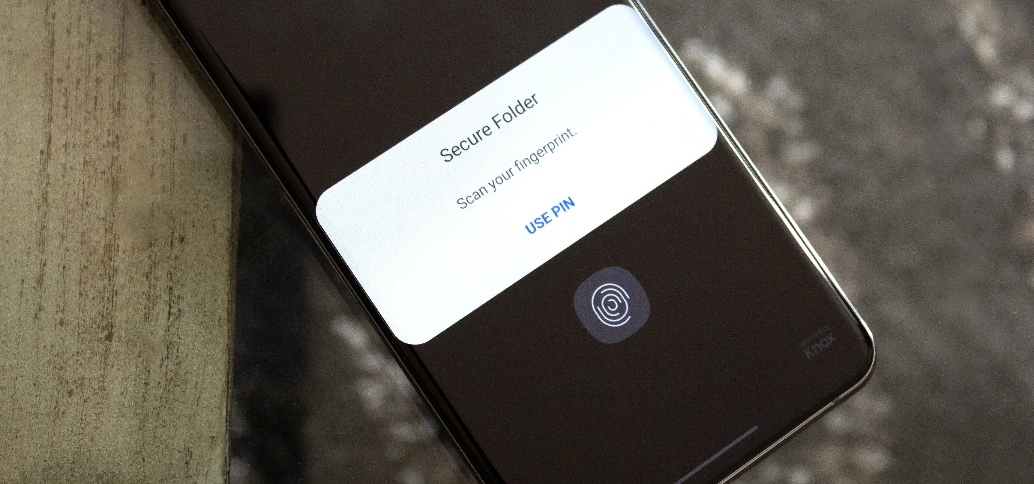 Smartphone showing a security prompt with fingerprint authentication option.