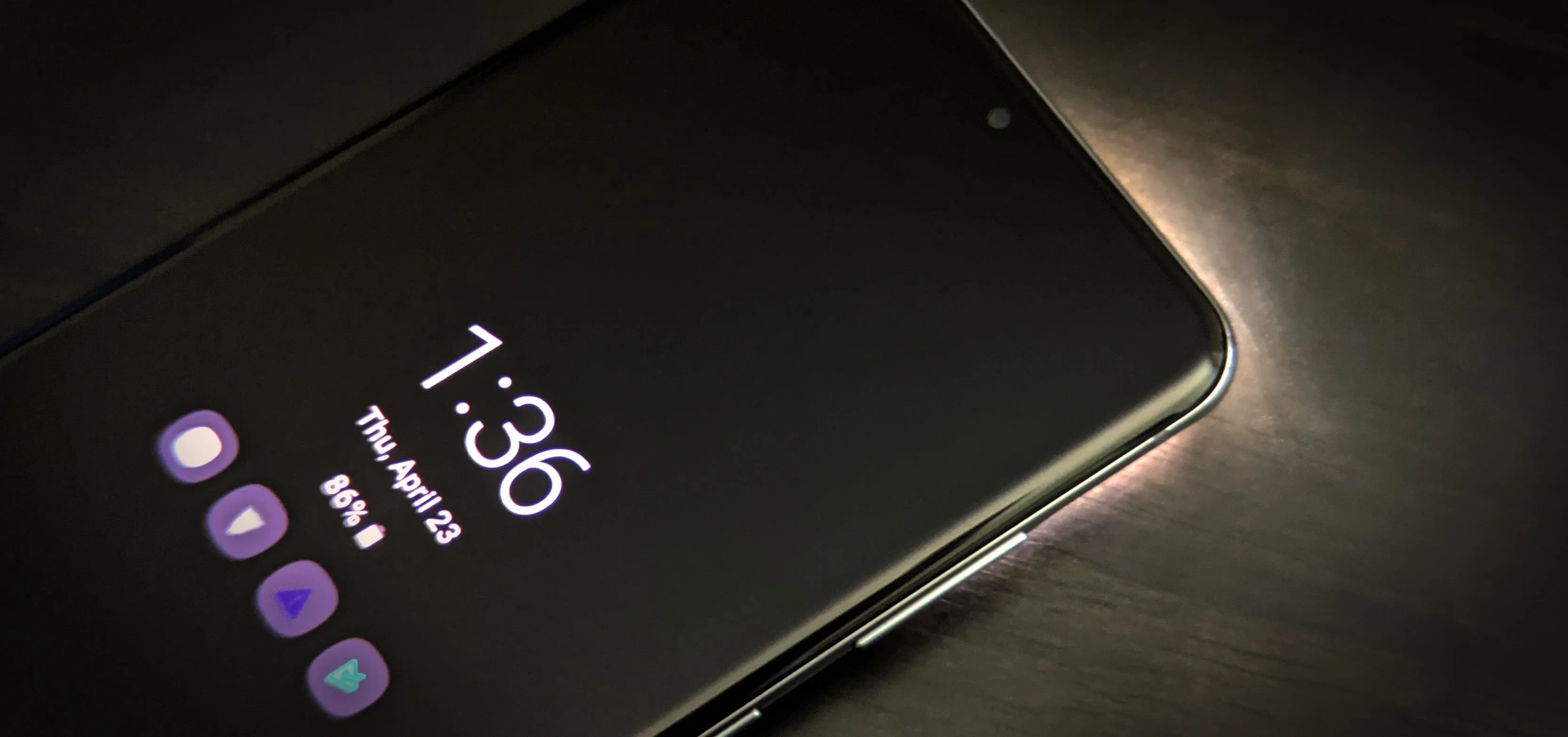 Smartphone displaying the time 1:36 and date, with a dark background.