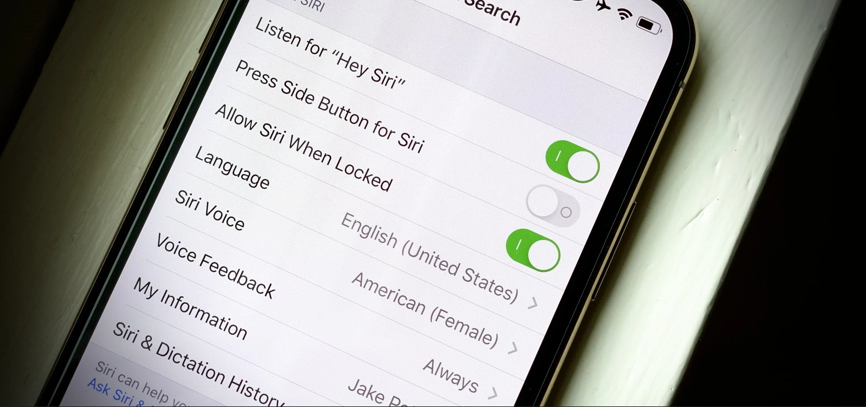 Settings menu on a smartphone displaying Siri options, including language and voice settings.