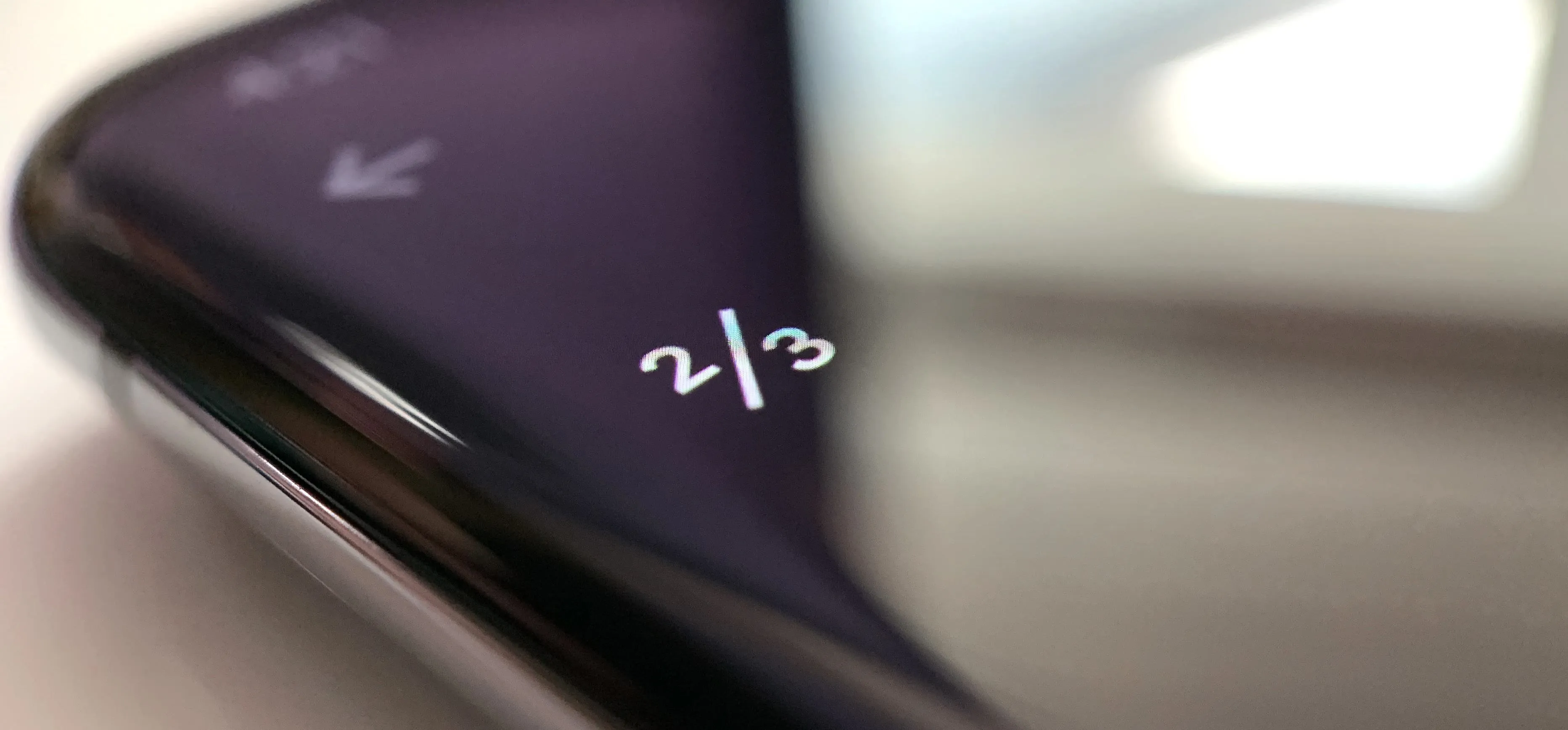 Image of a smartphone displaying "2/3" on its screen.