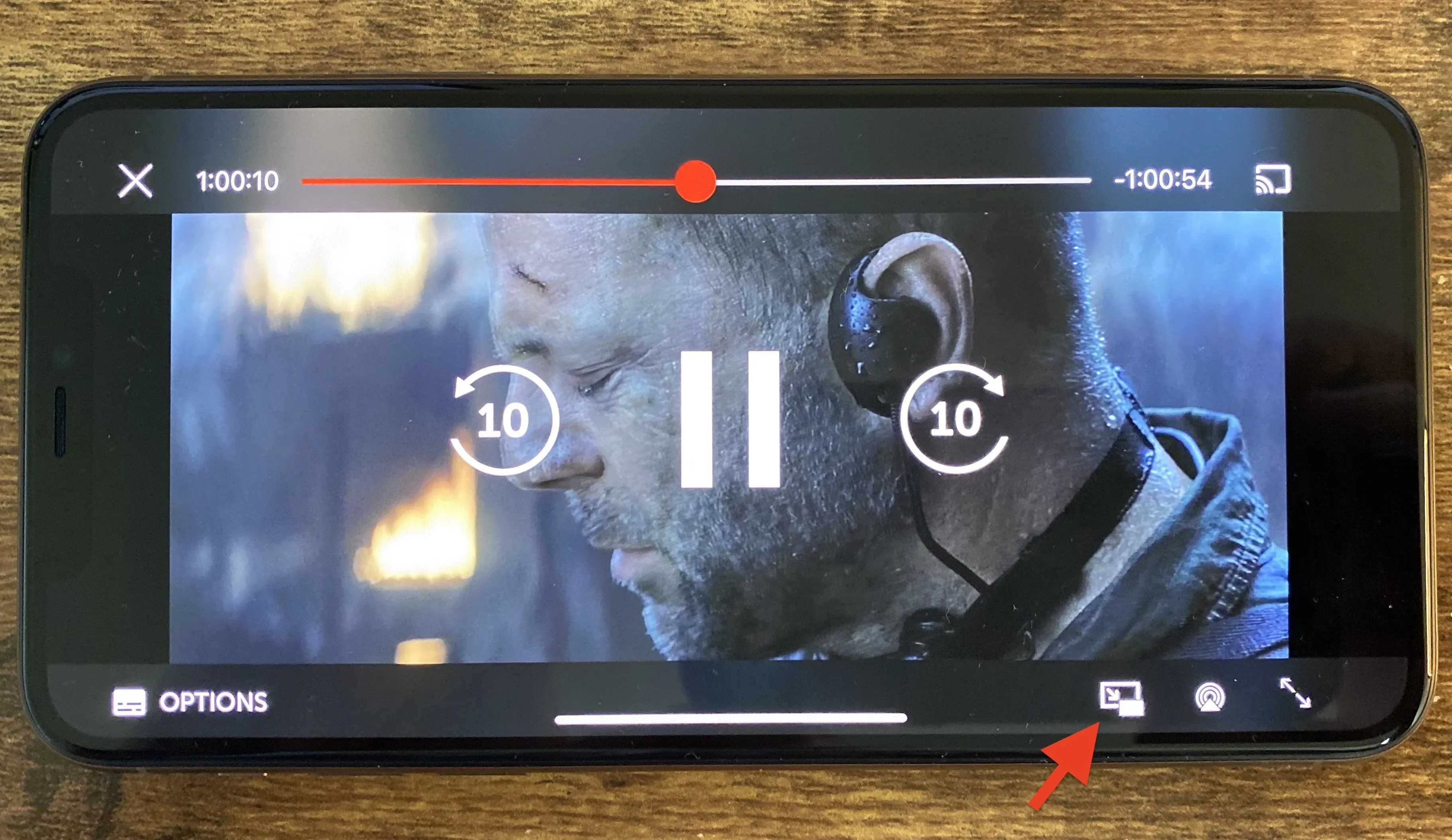 Video playback interface featuring a pause button and playback controls on a mobile device.