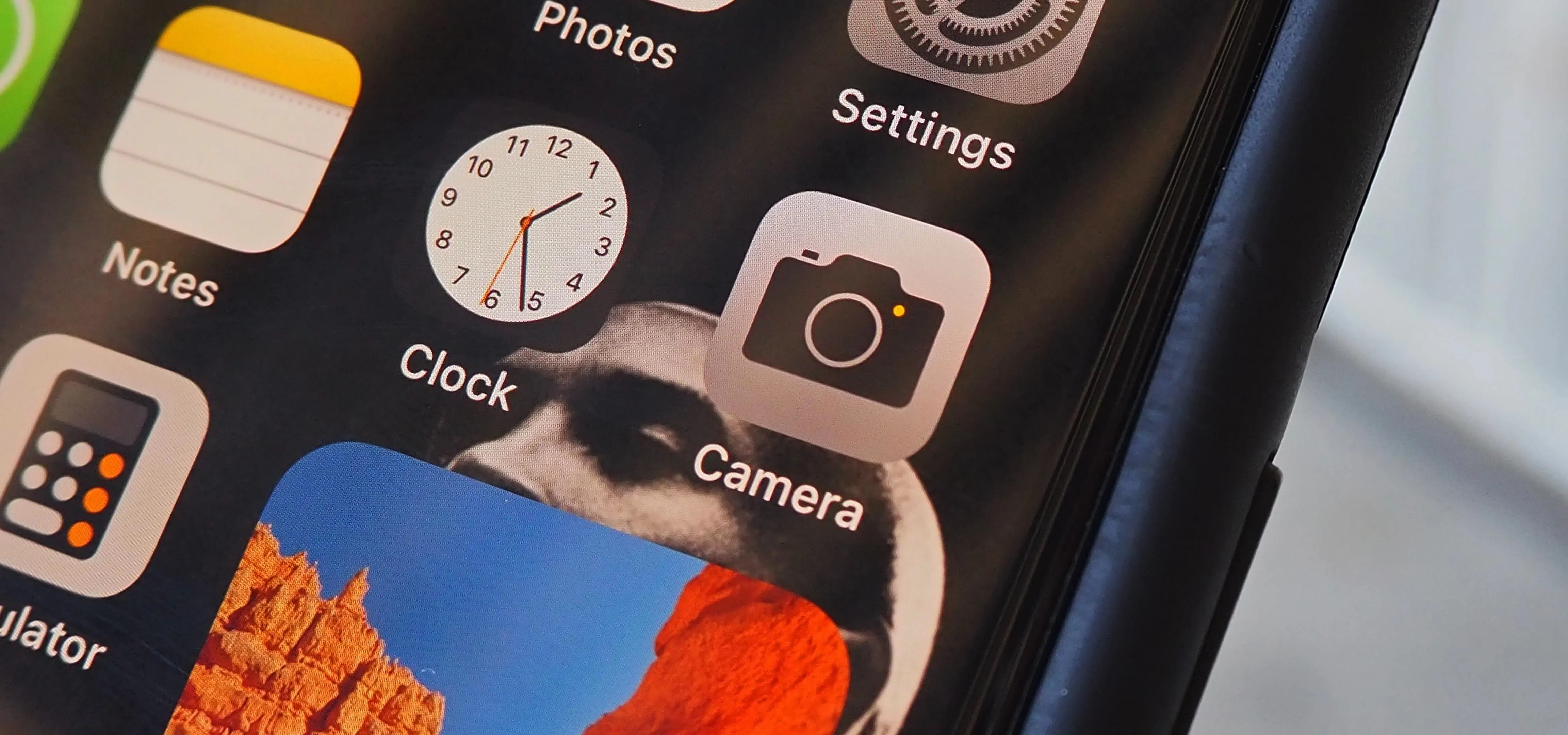 Smartphone home screen displaying various app icons including clock and camera.