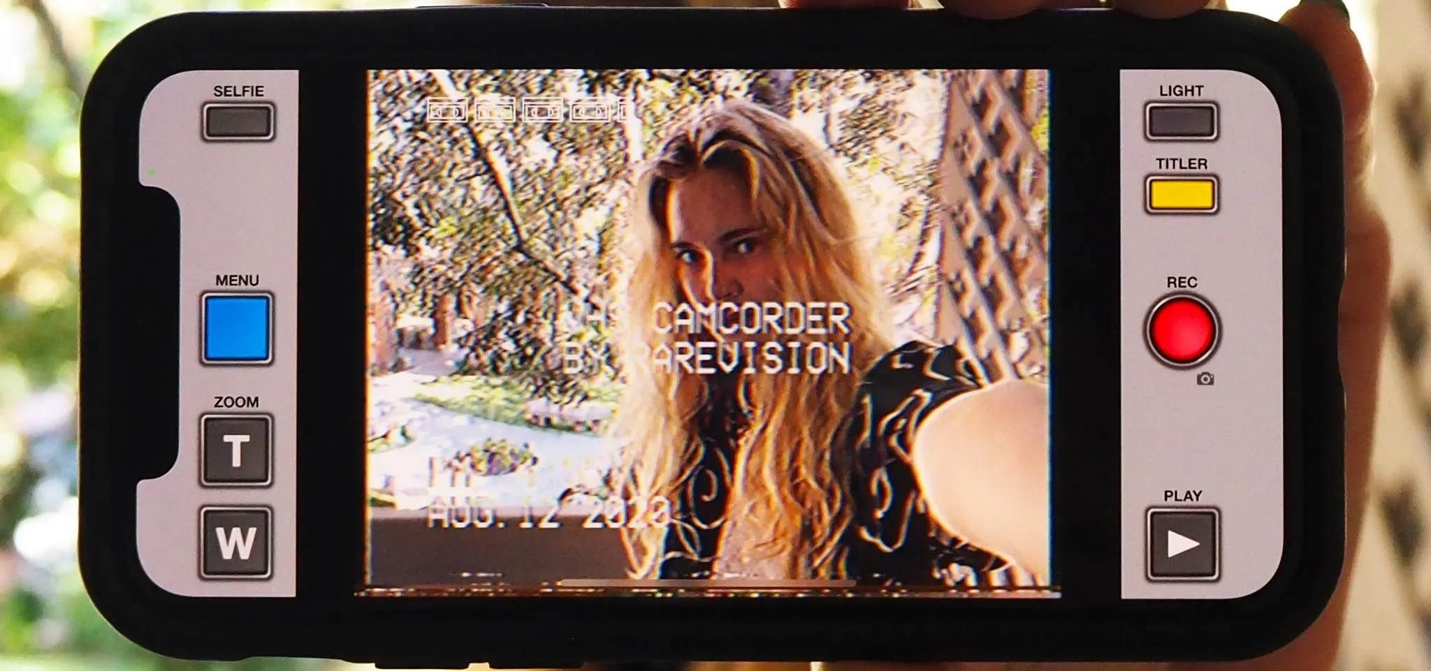 Person taking a selfie with a video camera display visible.