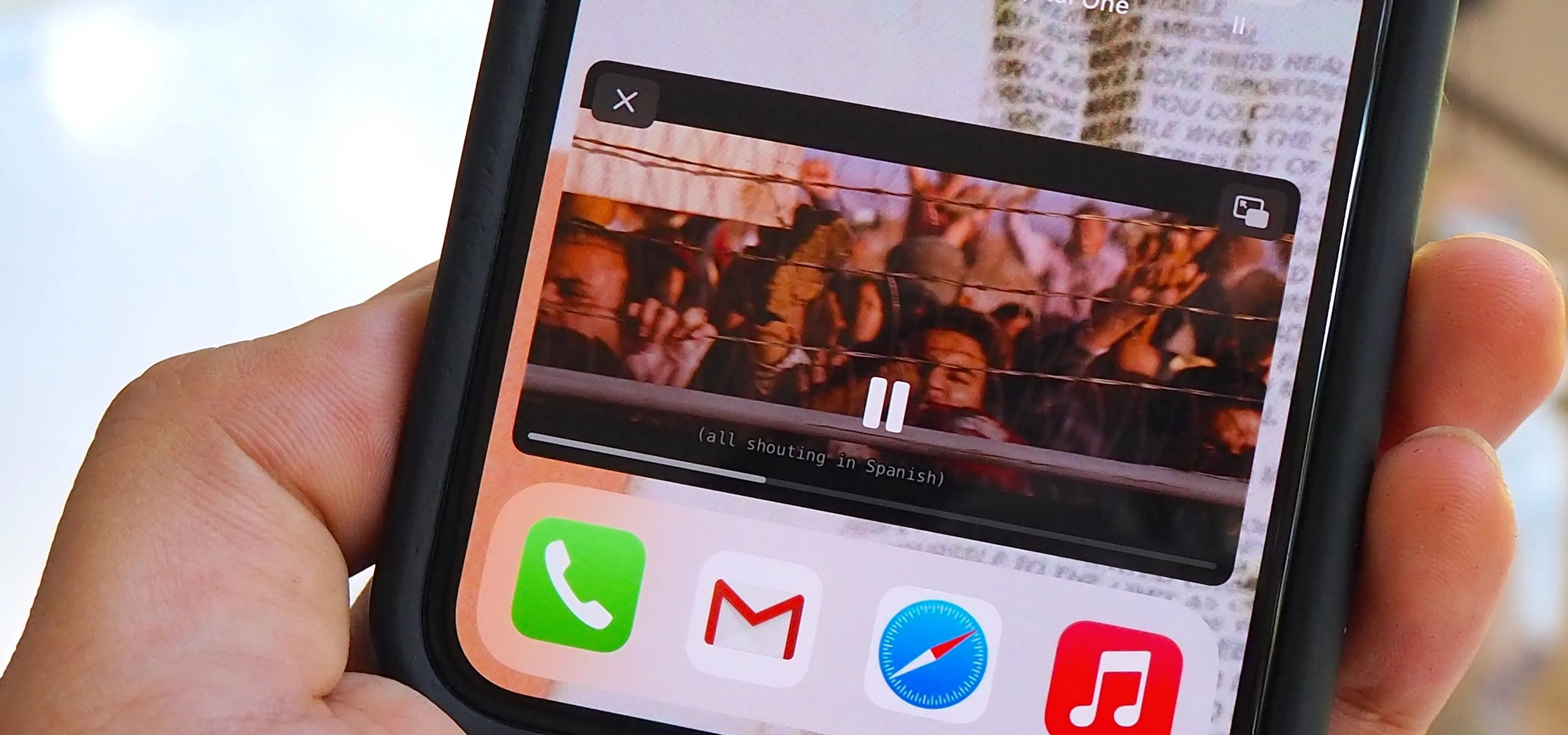 Smartphone displaying a video playback screen with app icons below.