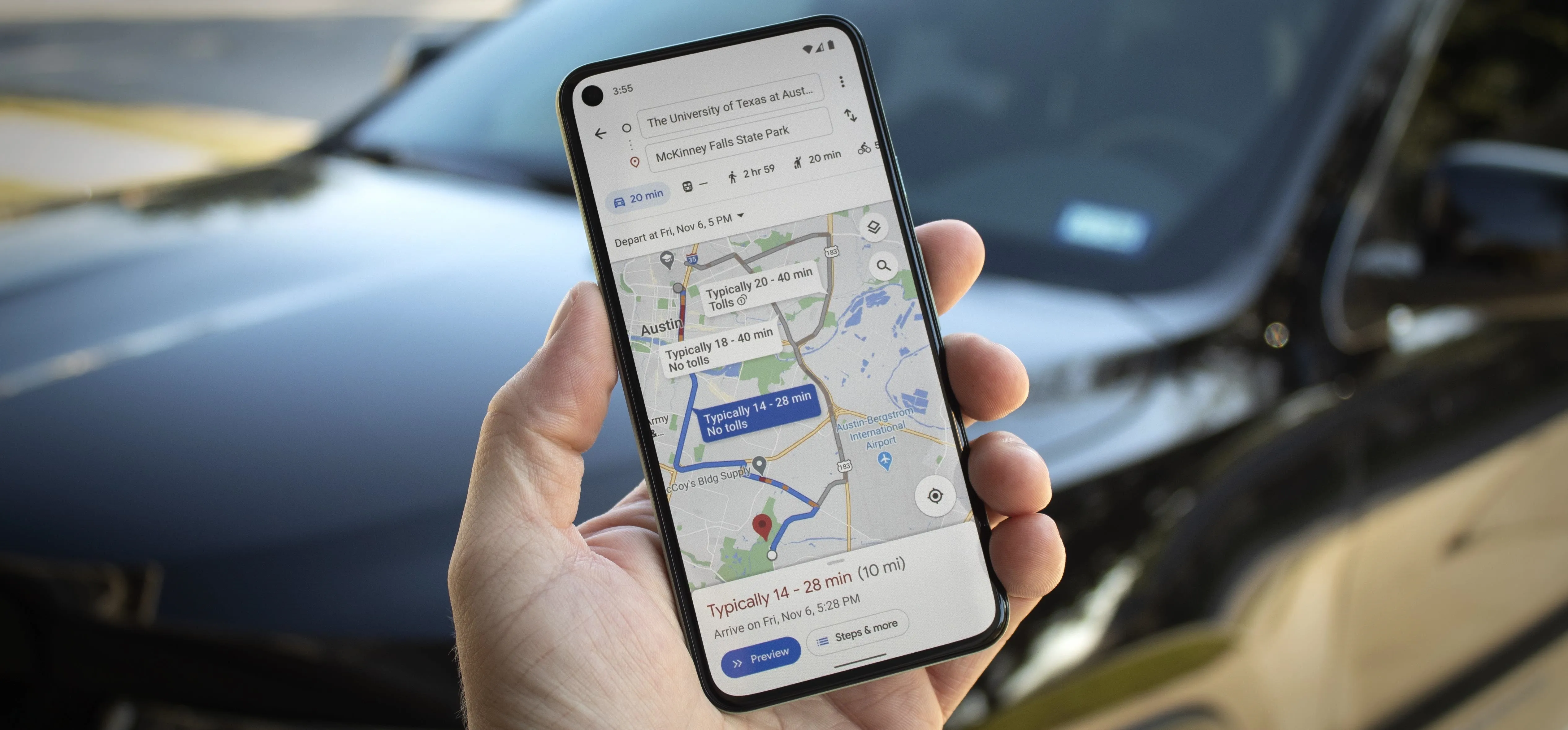 Person holding a smartphone displaying a map navigation app with a car in the background.