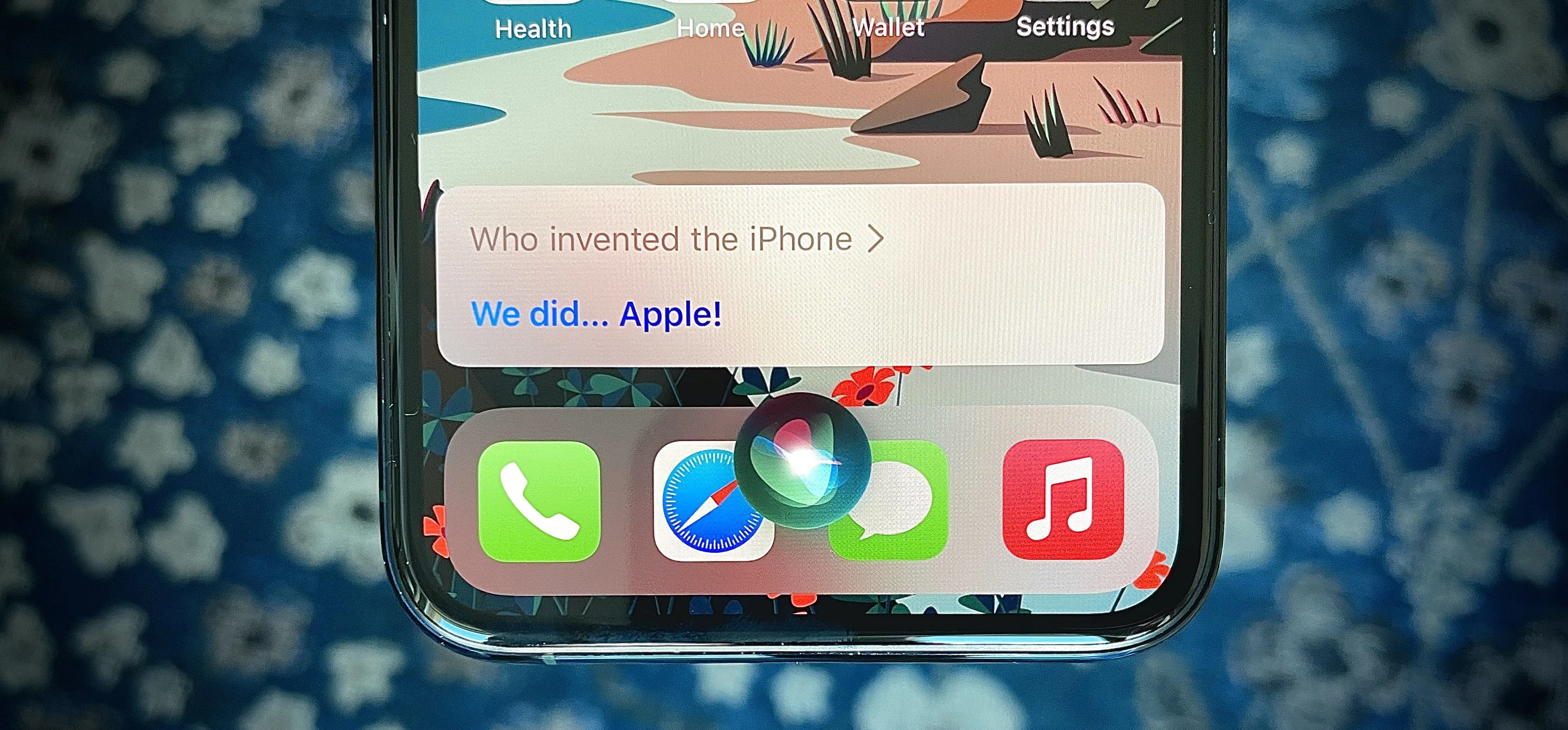 Smartphone screen displaying an app interface with a question about the invention of the iPhone.