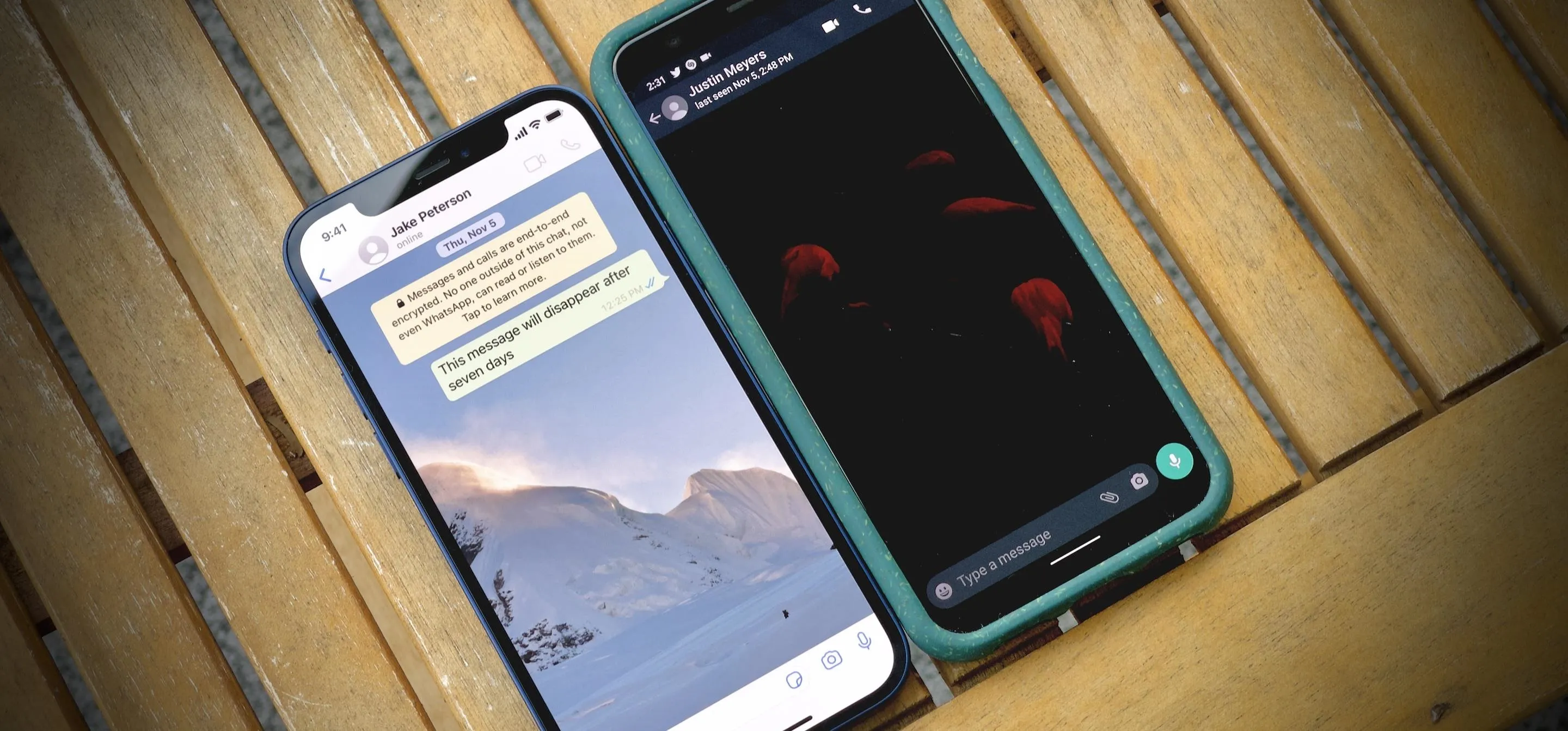 Two smartphones displaying messaging applications, placed on a wooden surface.