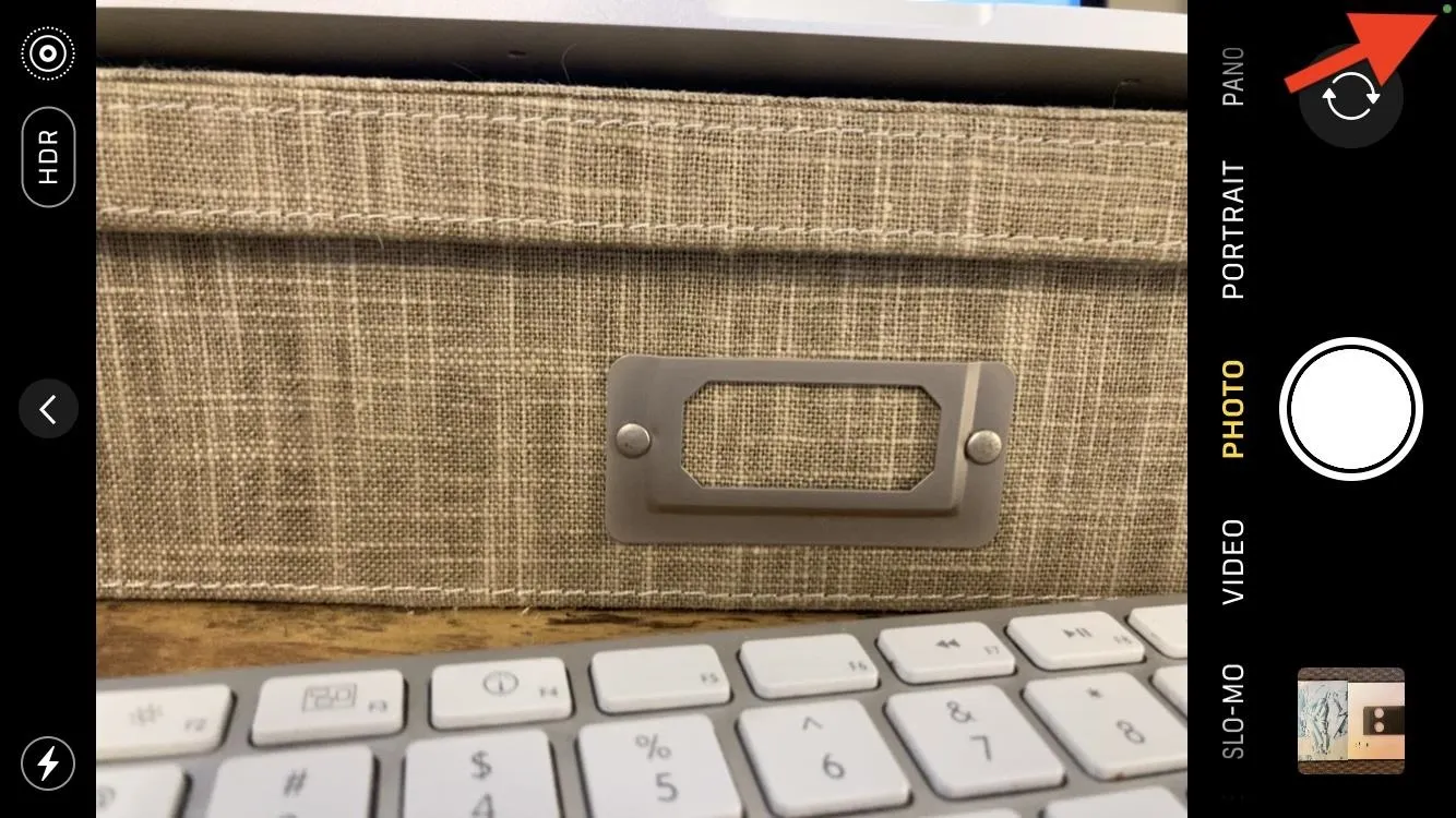 A textured storage box lid with a metal label holder above a keyboard.