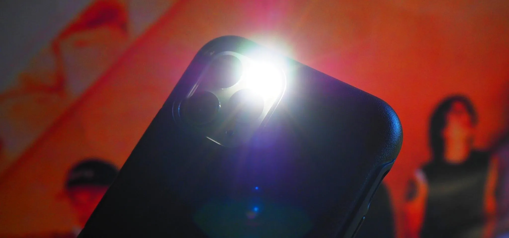 Smartphone camera flash in use with a colorful background.