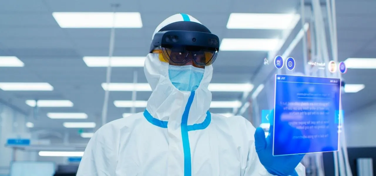Person in protective gear using augmented reality technology in a laboratory setting.