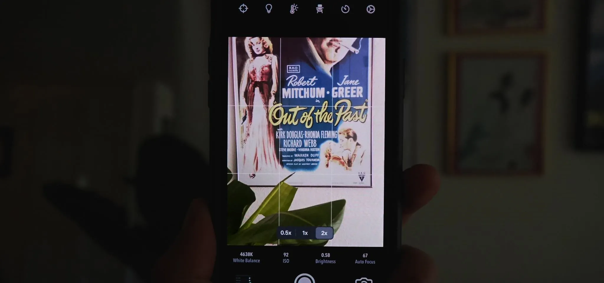 Image of a hand holding a smartphone displaying a vintage movie poster.