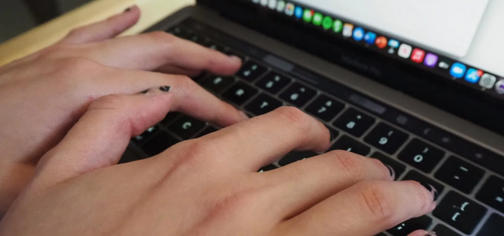 Hands typing on a laptop keyboard.