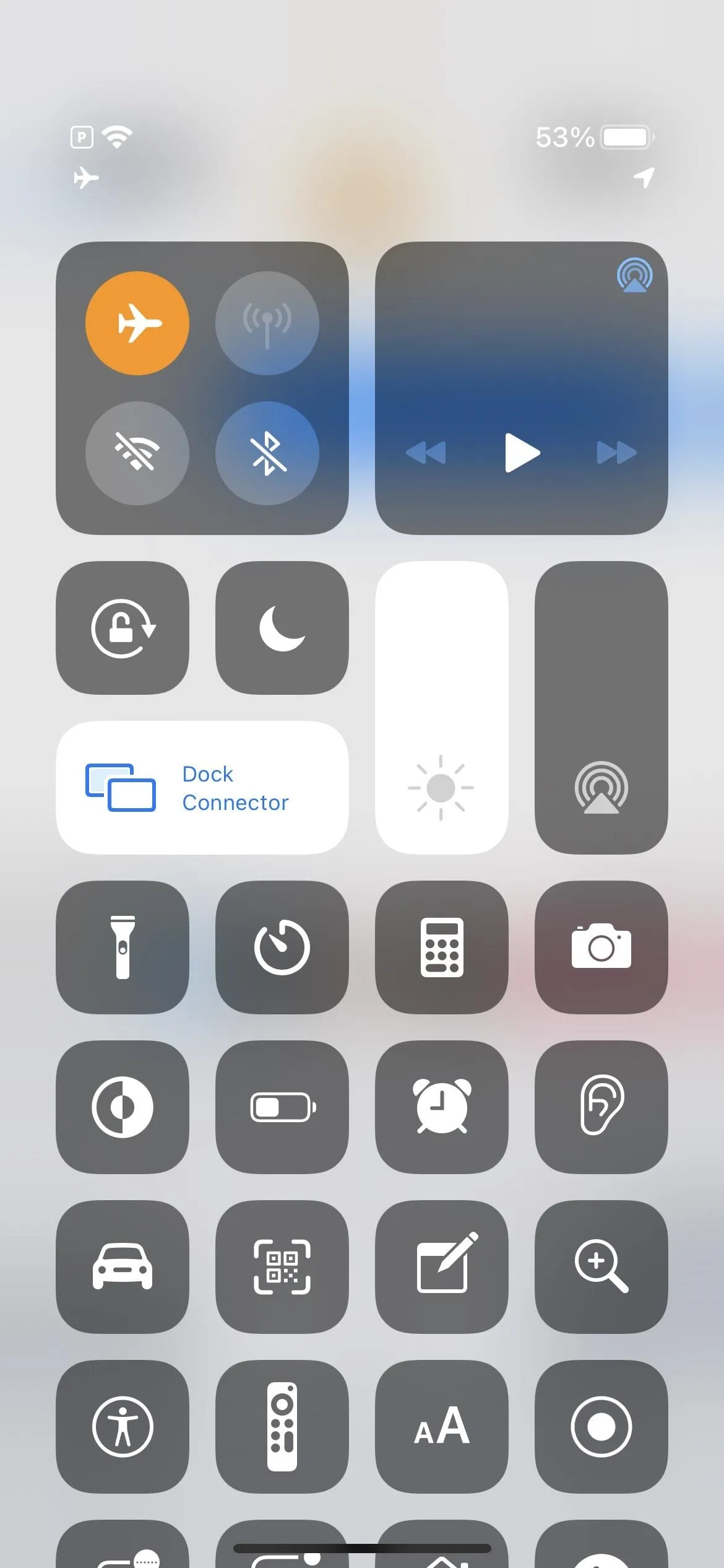 Smartphone control center interface with icons for settings, connectivity, and media playback.