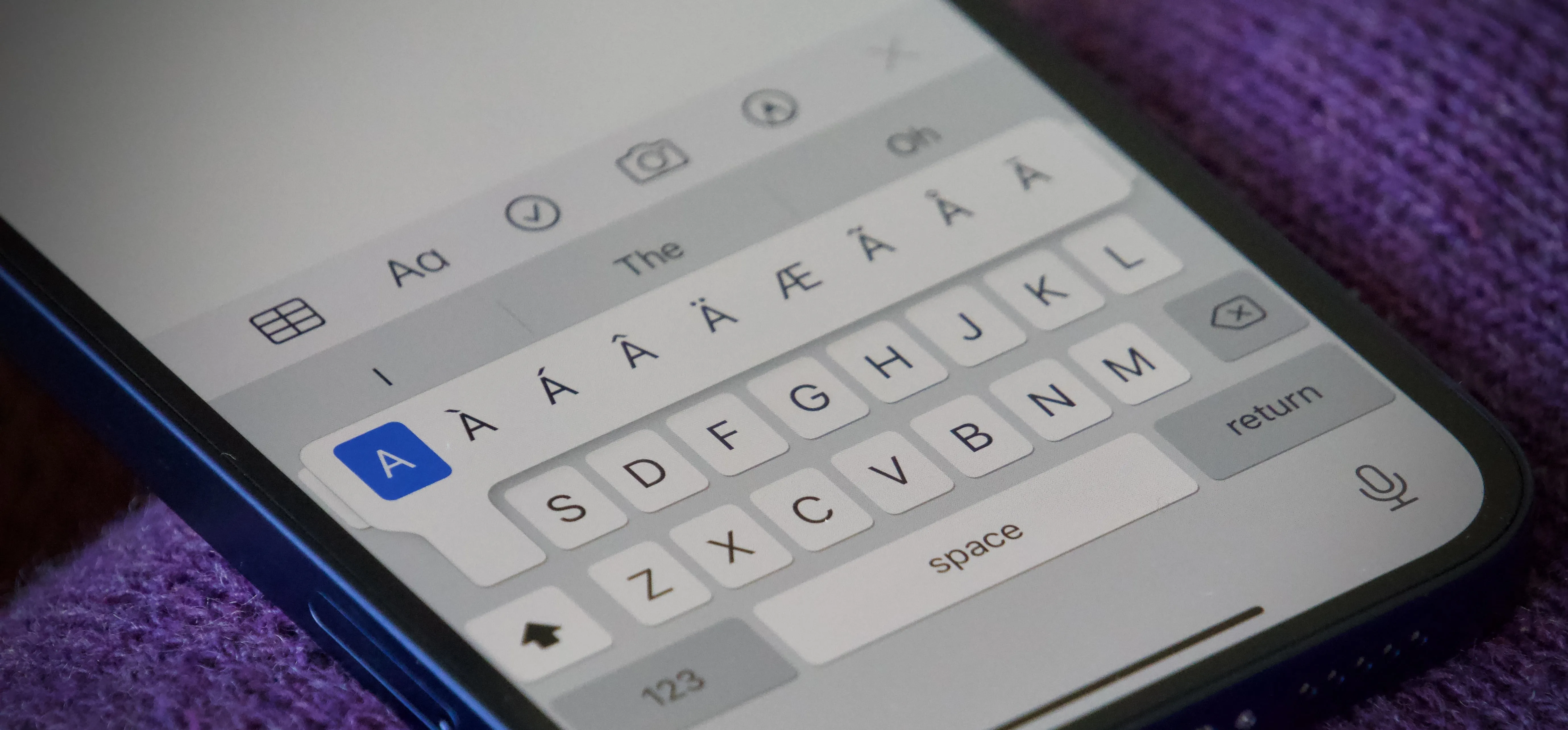 Close-up of a smartphone keyboard displaying text input options.