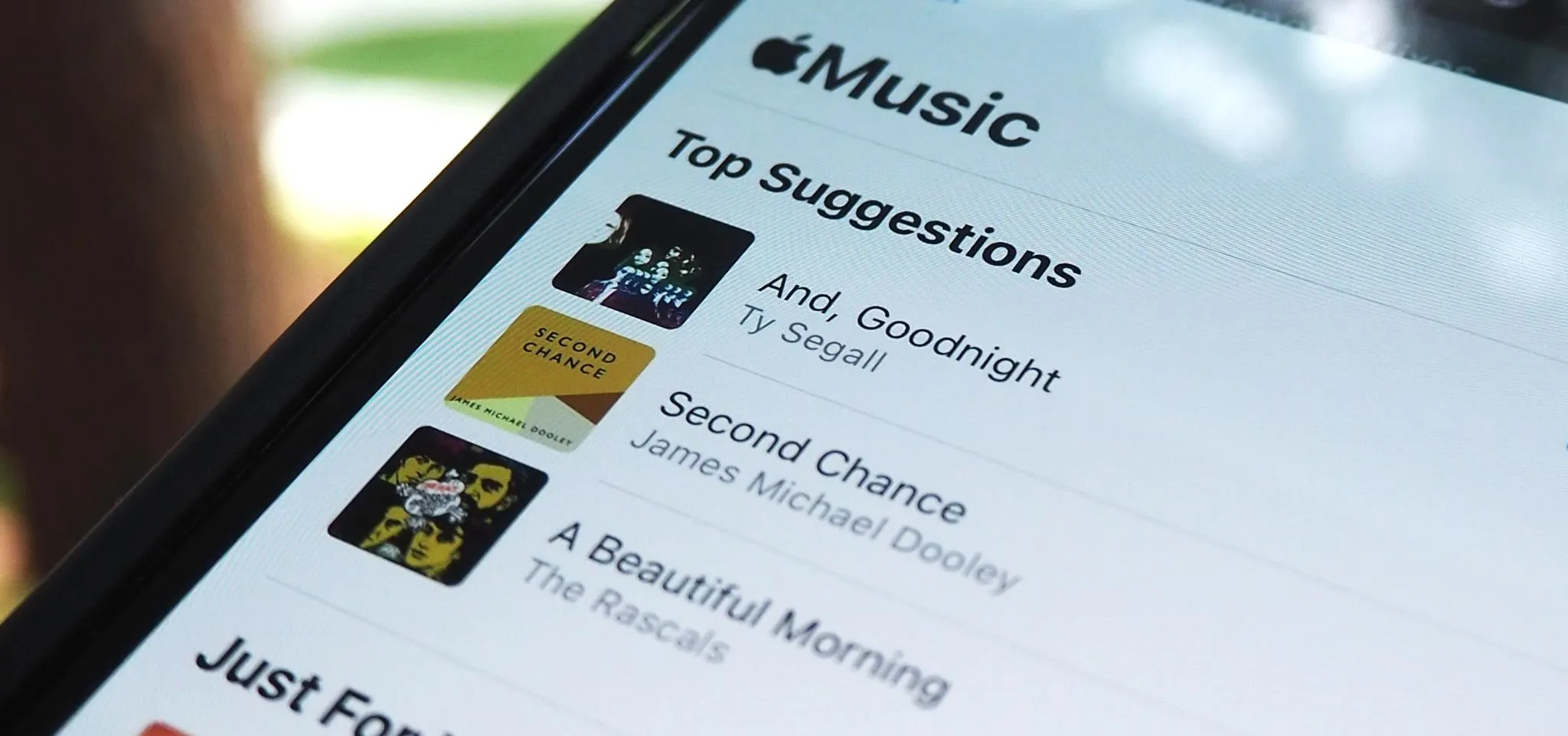 Apple Music interface showing top song suggestions.