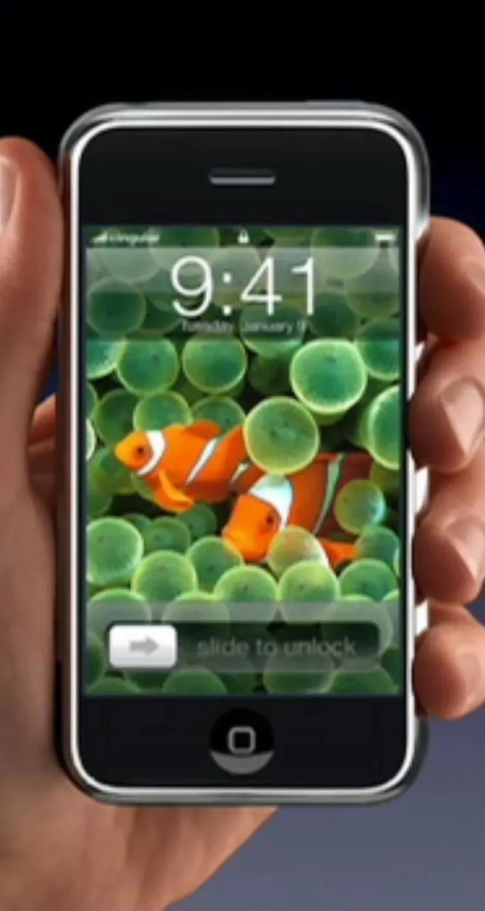 Smartphone displaying a colorful aquarium wallpaper with clowns fish.