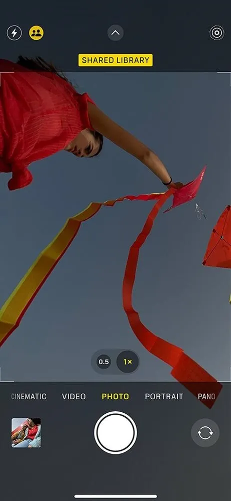 A person holding colorful ribbons against a blue sky.