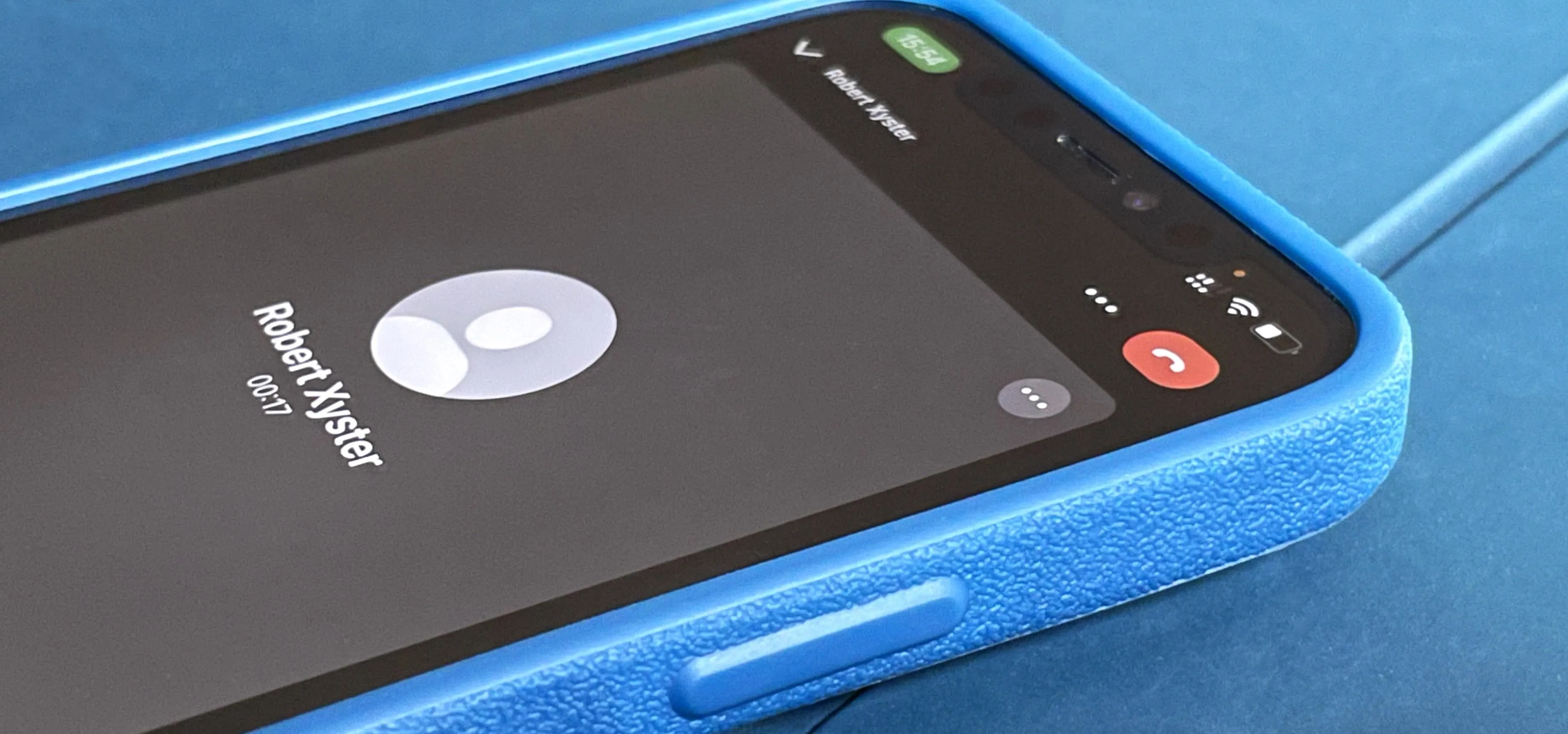 Incoming call screen on a smartphone with a blue case.