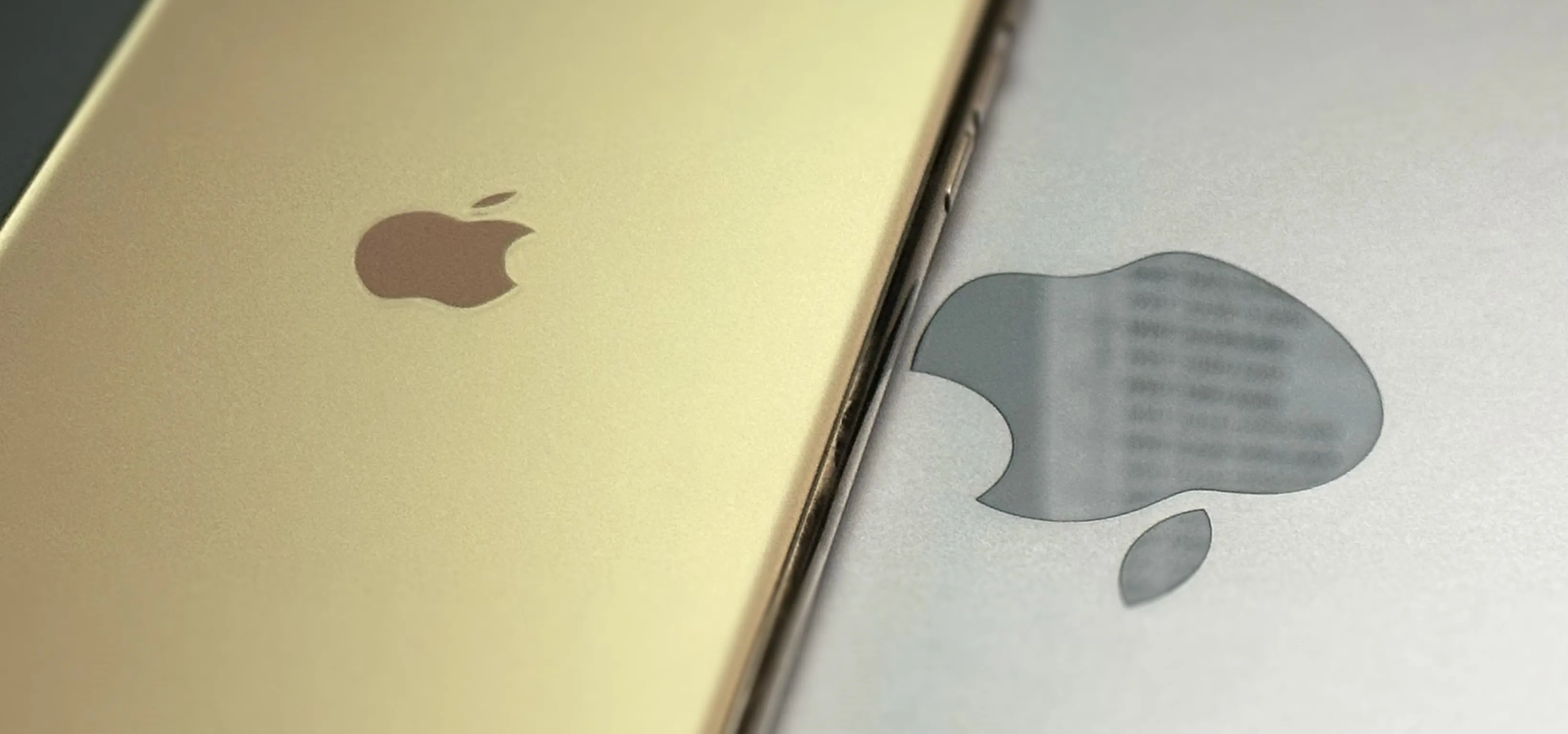 Two Apple smartphones, one gold and one silver, displaying their logos.