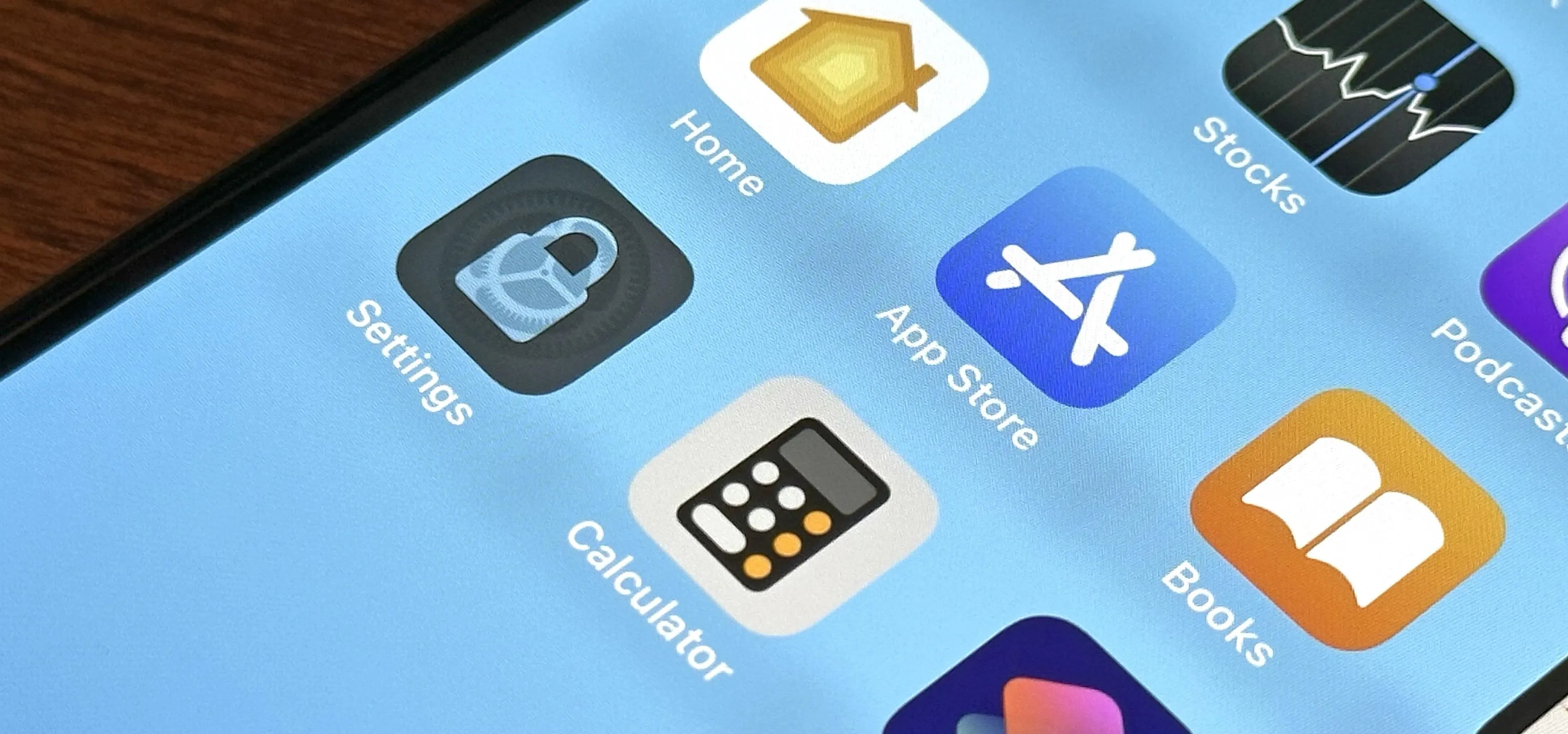 Smartphone screen displaying various app icons, including Settings, Calculator, App Store, and Books.