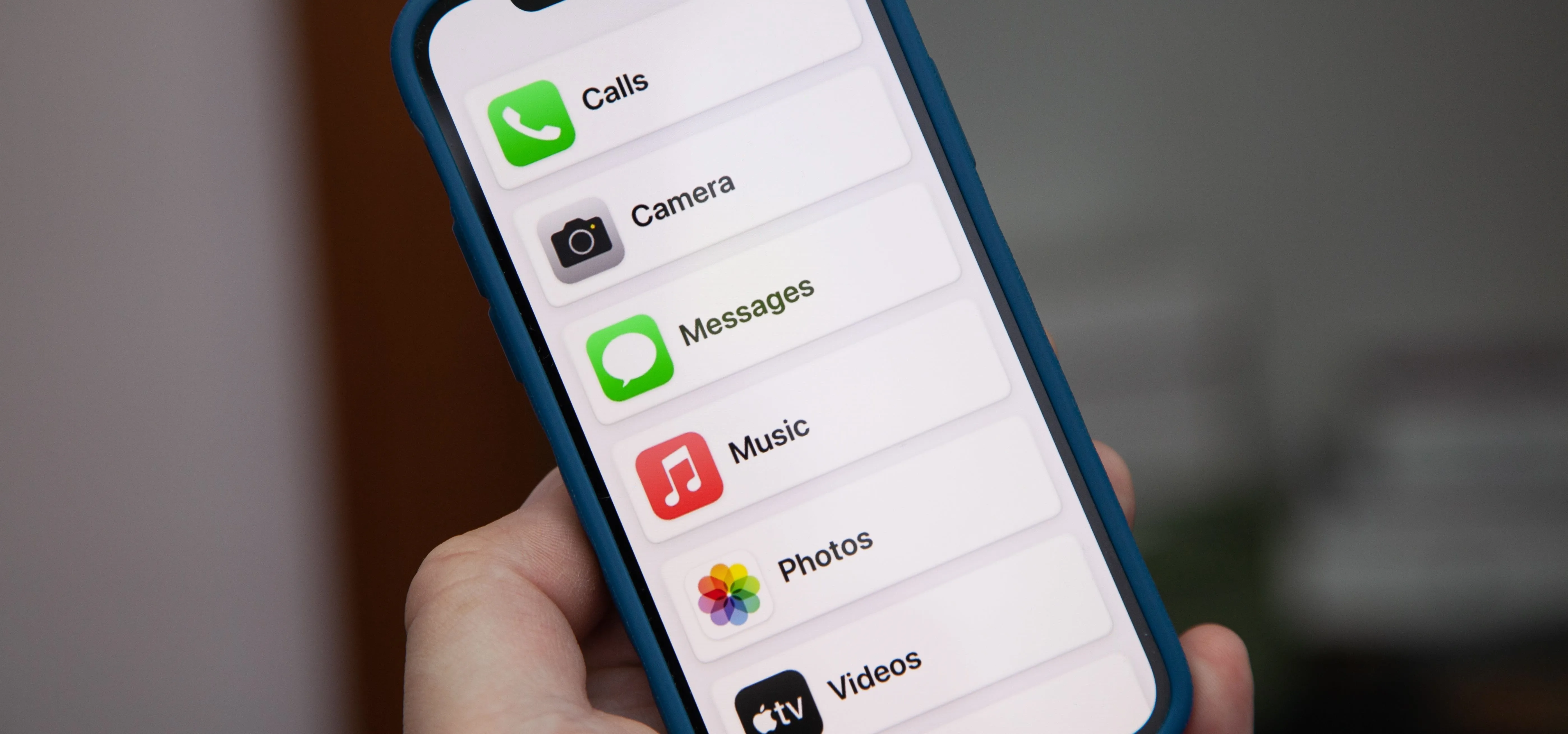 Smartphone displaying application options including Call, Camera, Messages, Music, Photos, and Videos.