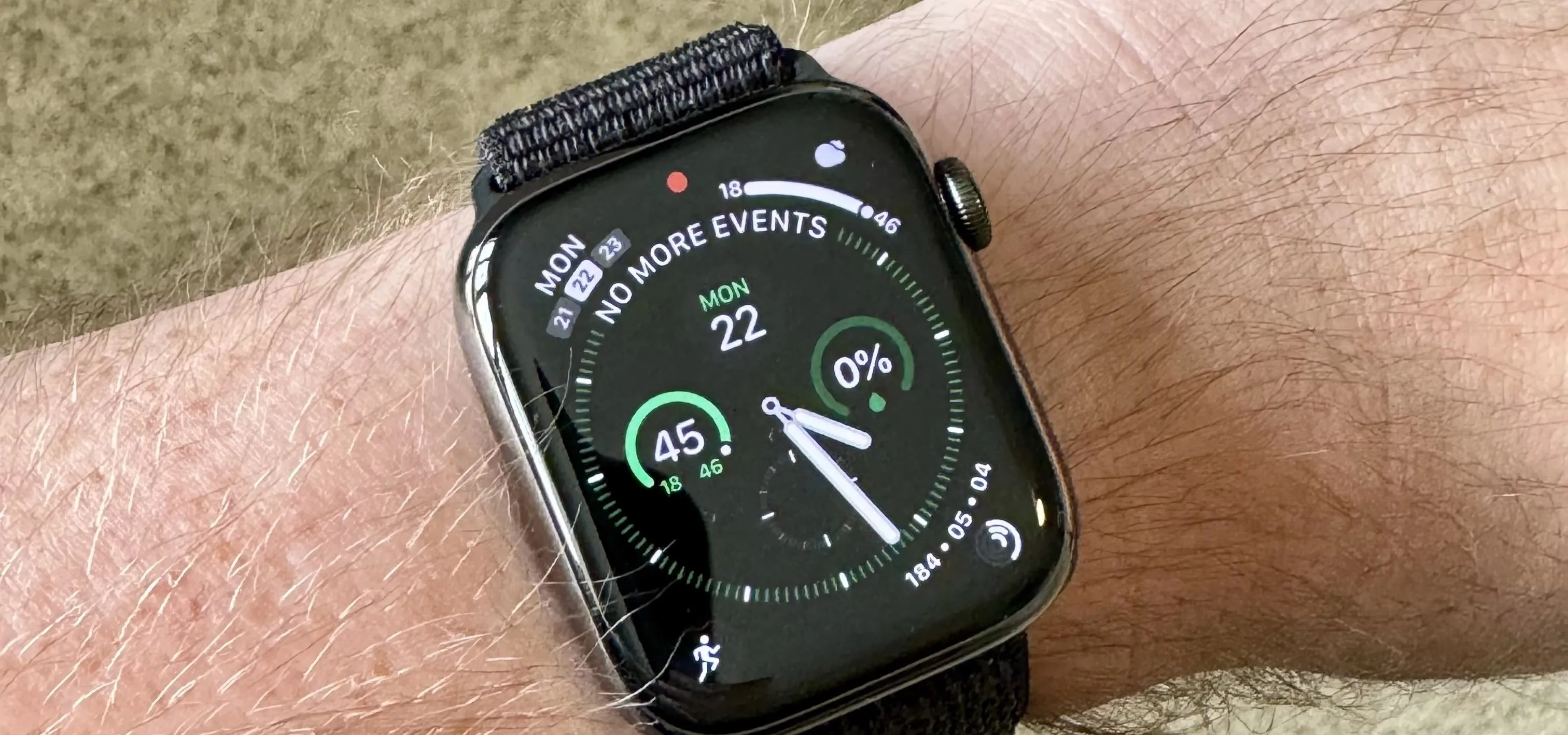 Apple Watch on a wrist displaying the Apple logo.