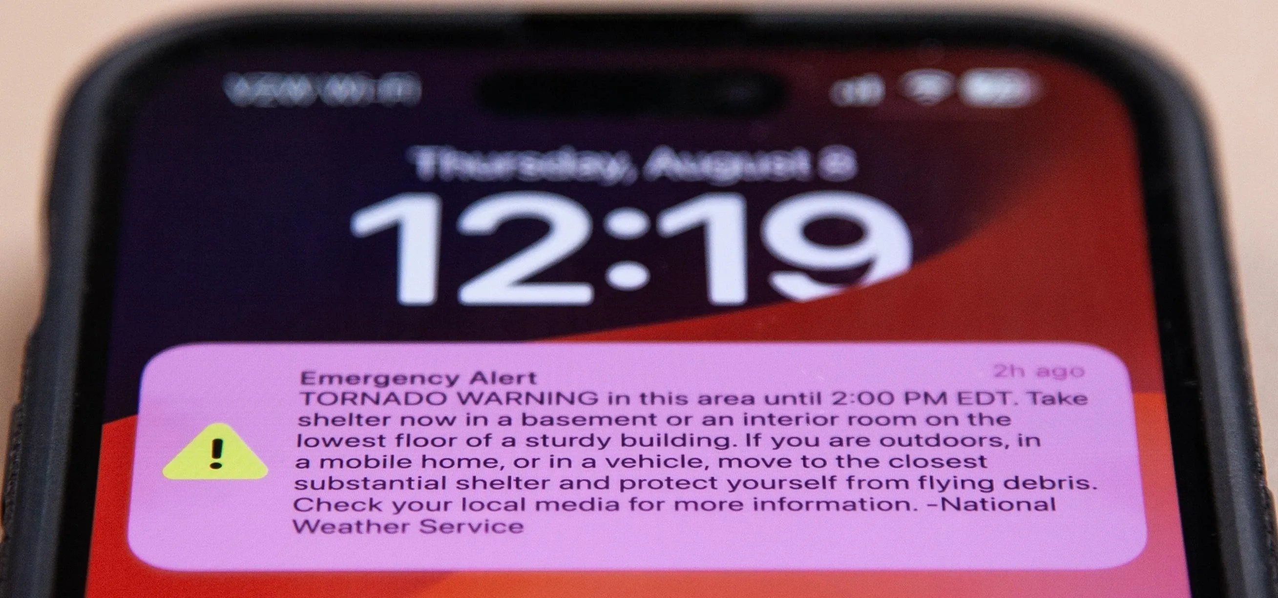 Emergency alert regarding a tornado warning on a smartphone screen.