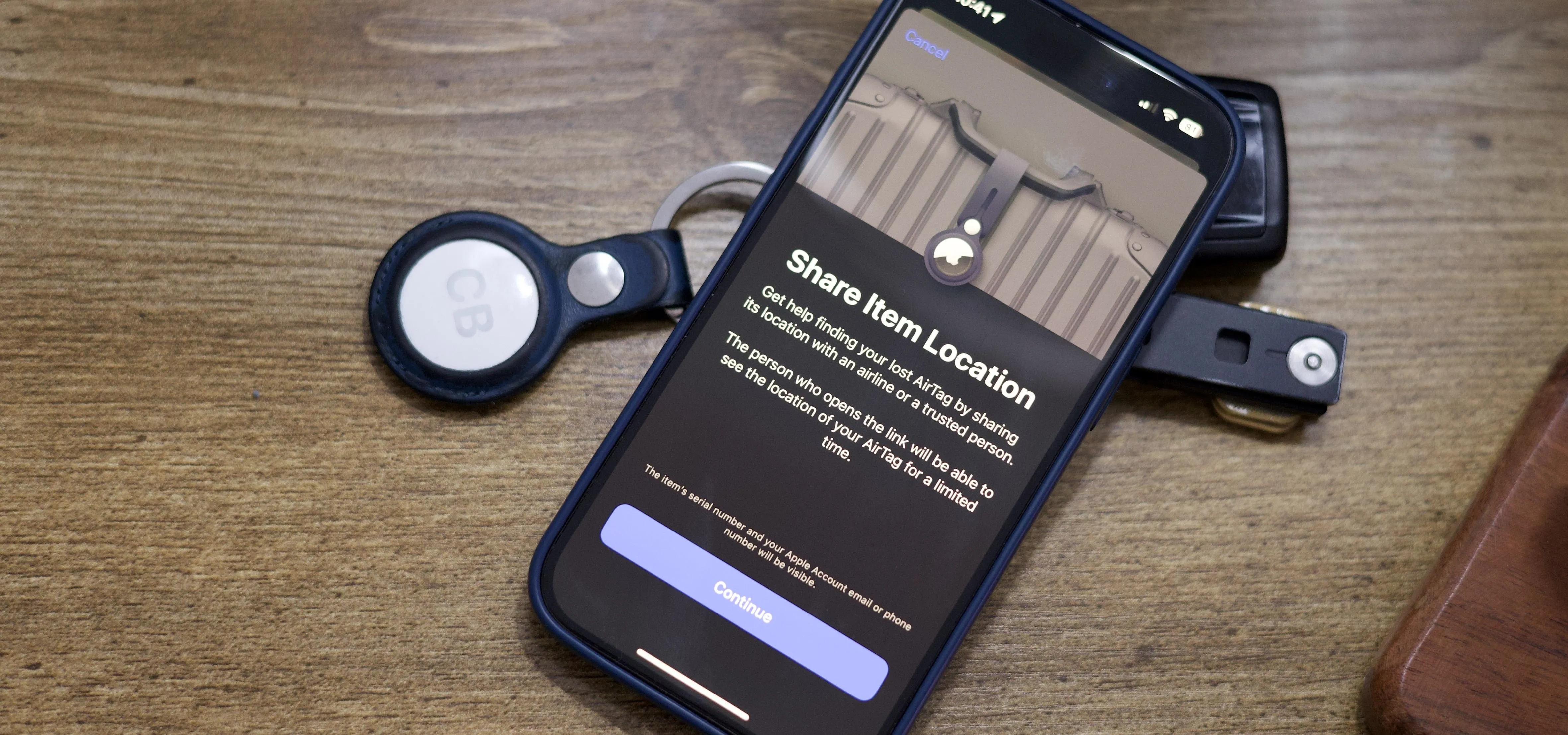 Smartphone displaying location sharing settings on a wooden surface, surrounded by keys and a wallet.