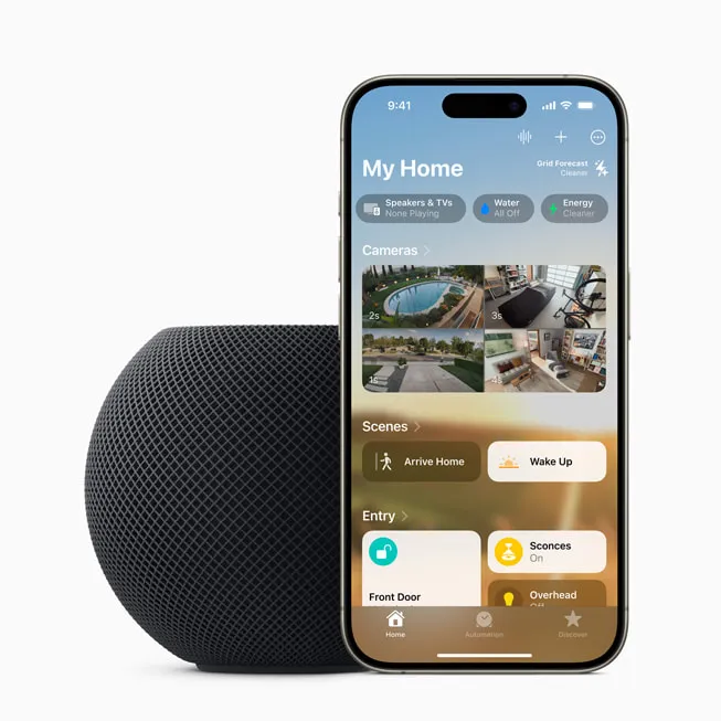 Midnight HomePod mini beside an iPhone displaying the Home app, illustrating the Apple–ADT smart home partnership rumor