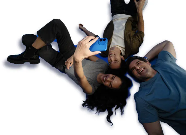 Three people lying together and smiling for a selfie taken with a blue smartphone