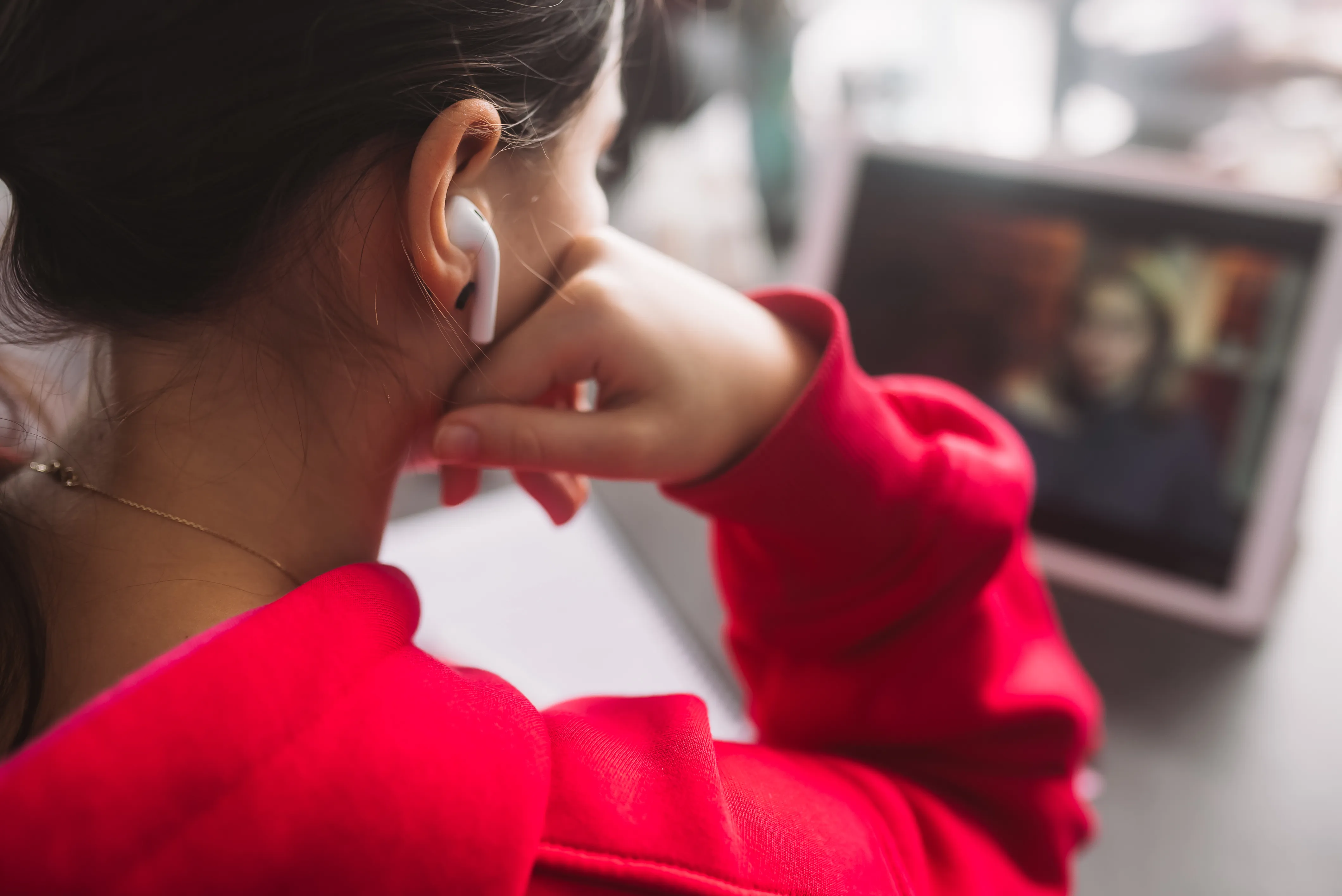 image of someone watching a video on a table wearing wireless earphones