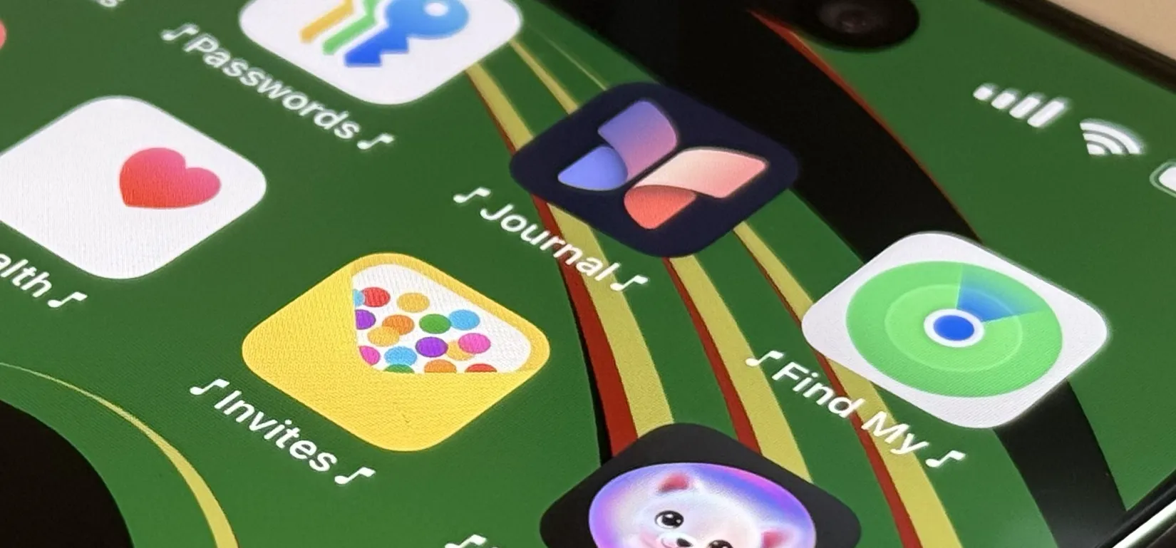 A hand holding a smartphone with colorful toy figures in the background.